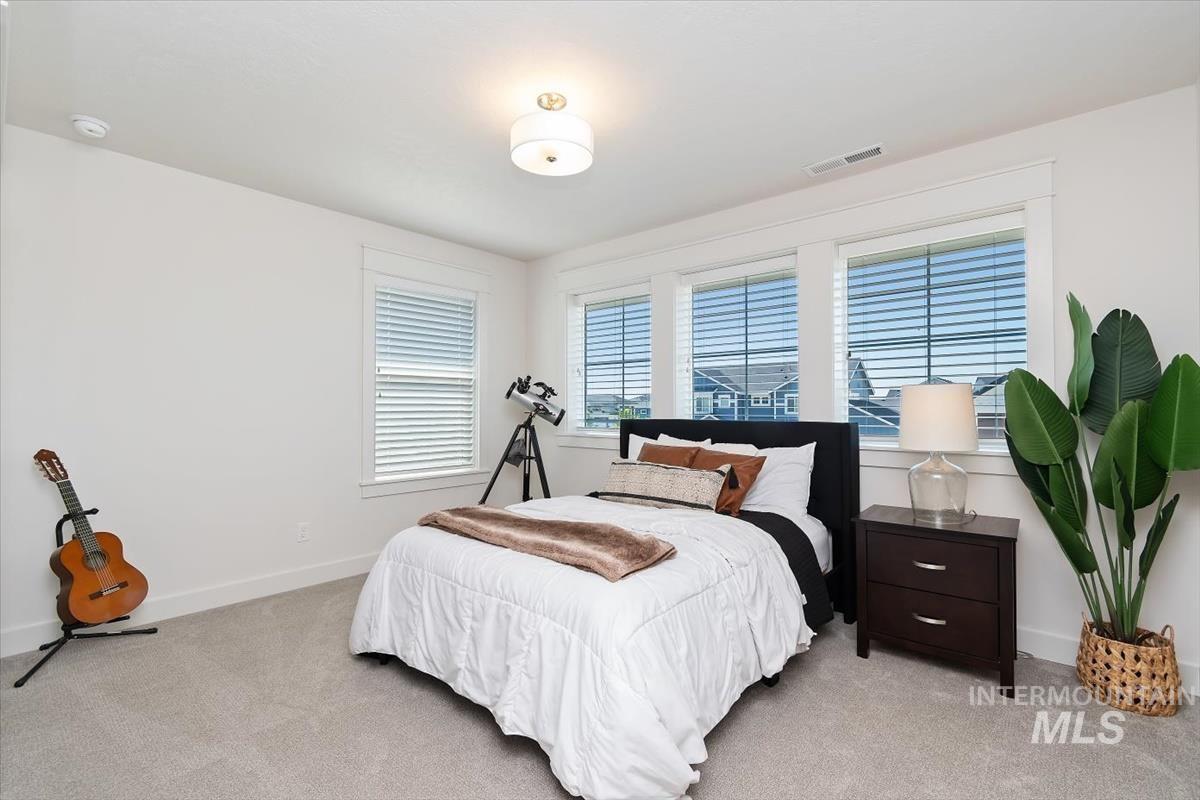 Bedroom featuring light gray carpeting, crisp white walls, and a recessed ceiling light fixture