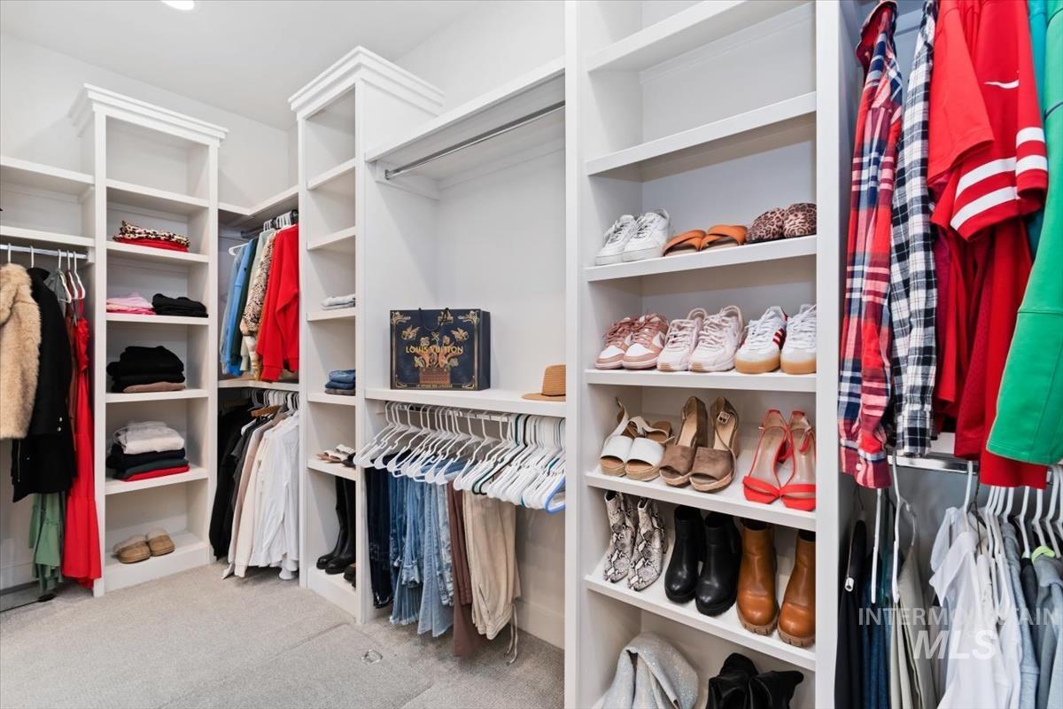 Custom built-in closet system featuring white shelving and hanging rods