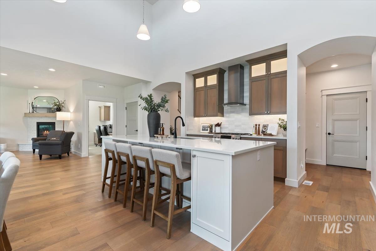 Spacious kitchen island with a white countertop and seating for four, complemented by wood-finish flooring