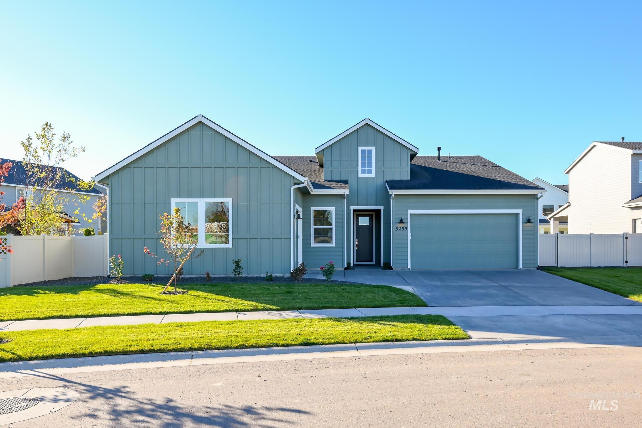 View of front of property featuring board and batten siding, driveway, and an attached garage