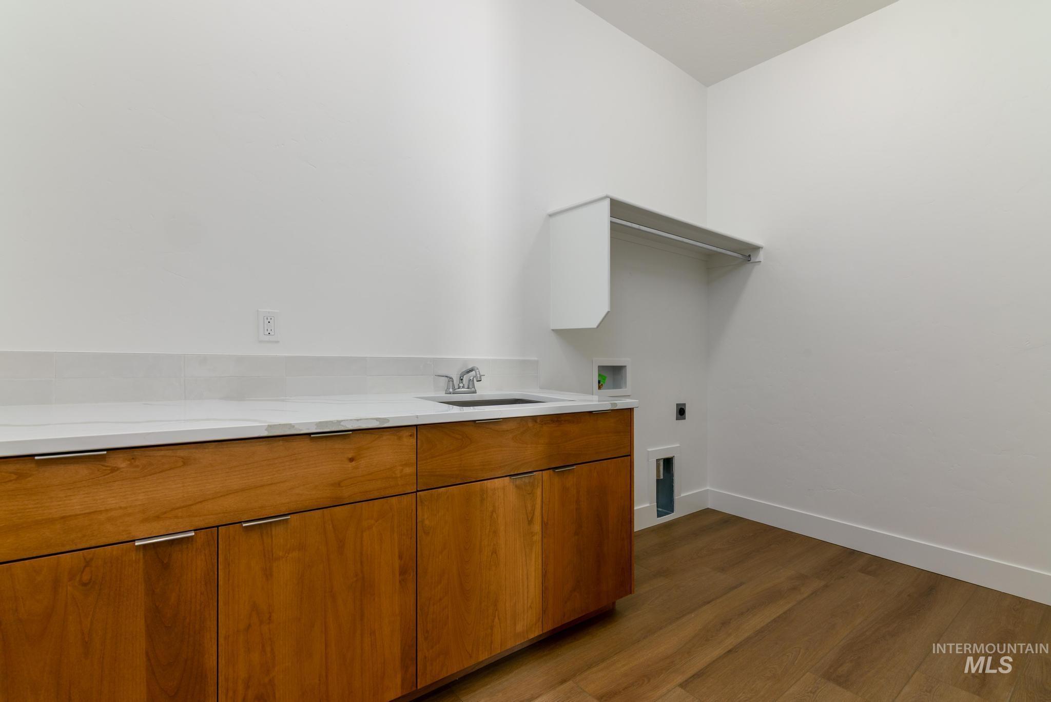 Washroom featuring dark wood-type flooring, washer hookup, and electric dryer hookup