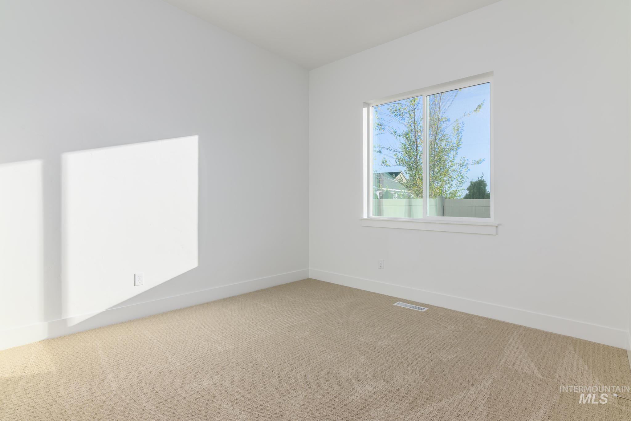 Empty room featuring light colored carpet
