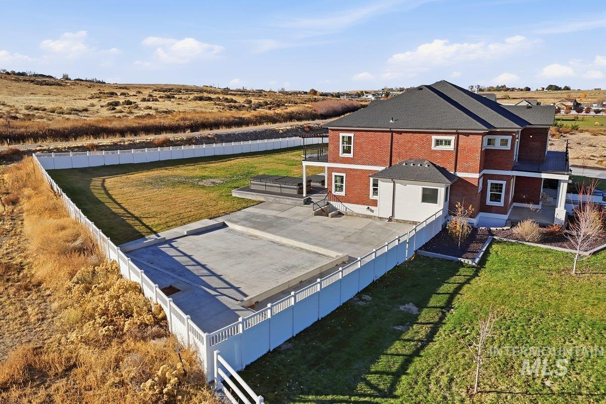 Rear view of house featuring a fenced backyard, a patio area, and brick siding