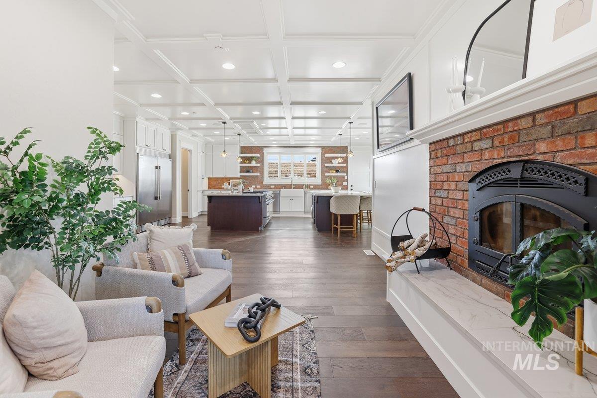 Living room with dark wood finished floors, coffered ceiling, beamed ceiling, and recessed lighting