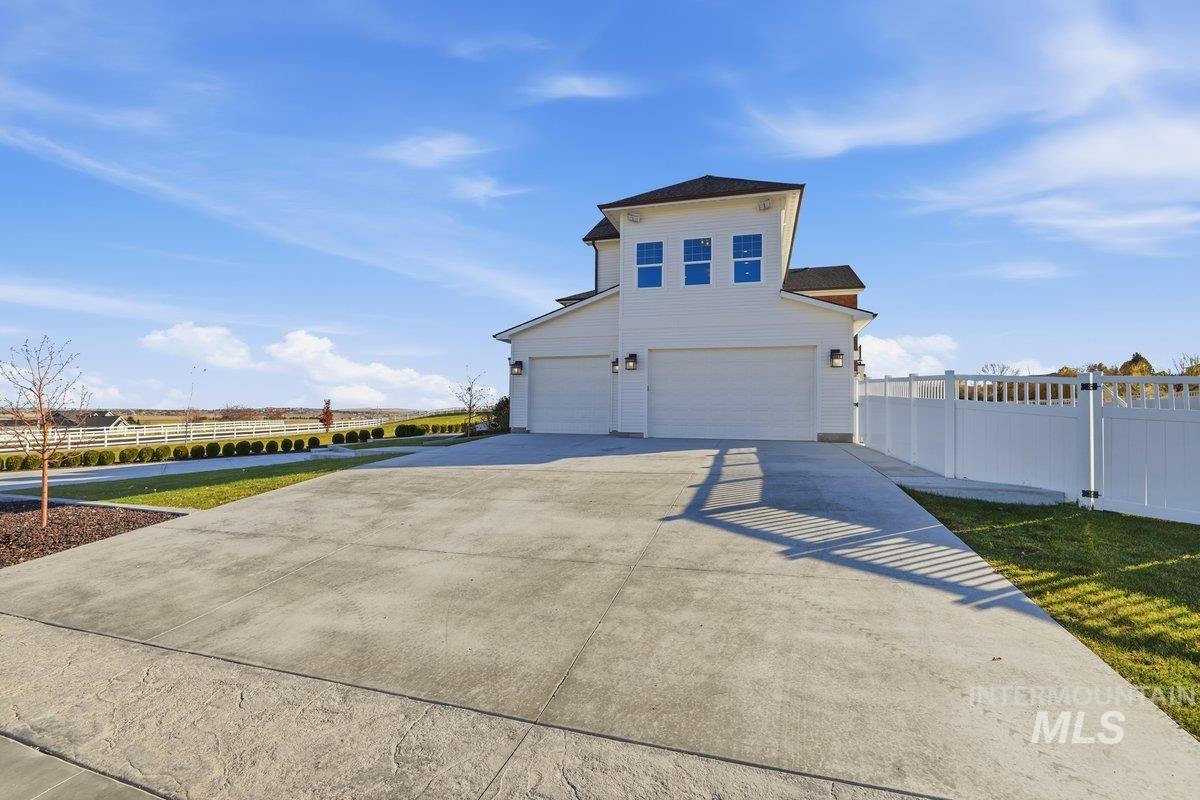 View of front of property with concrete driveway and an attached garage