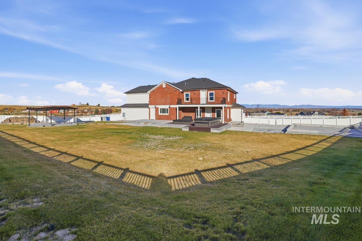 Back of house featuring a patio, brick siding, a fenced backyard, and a water view