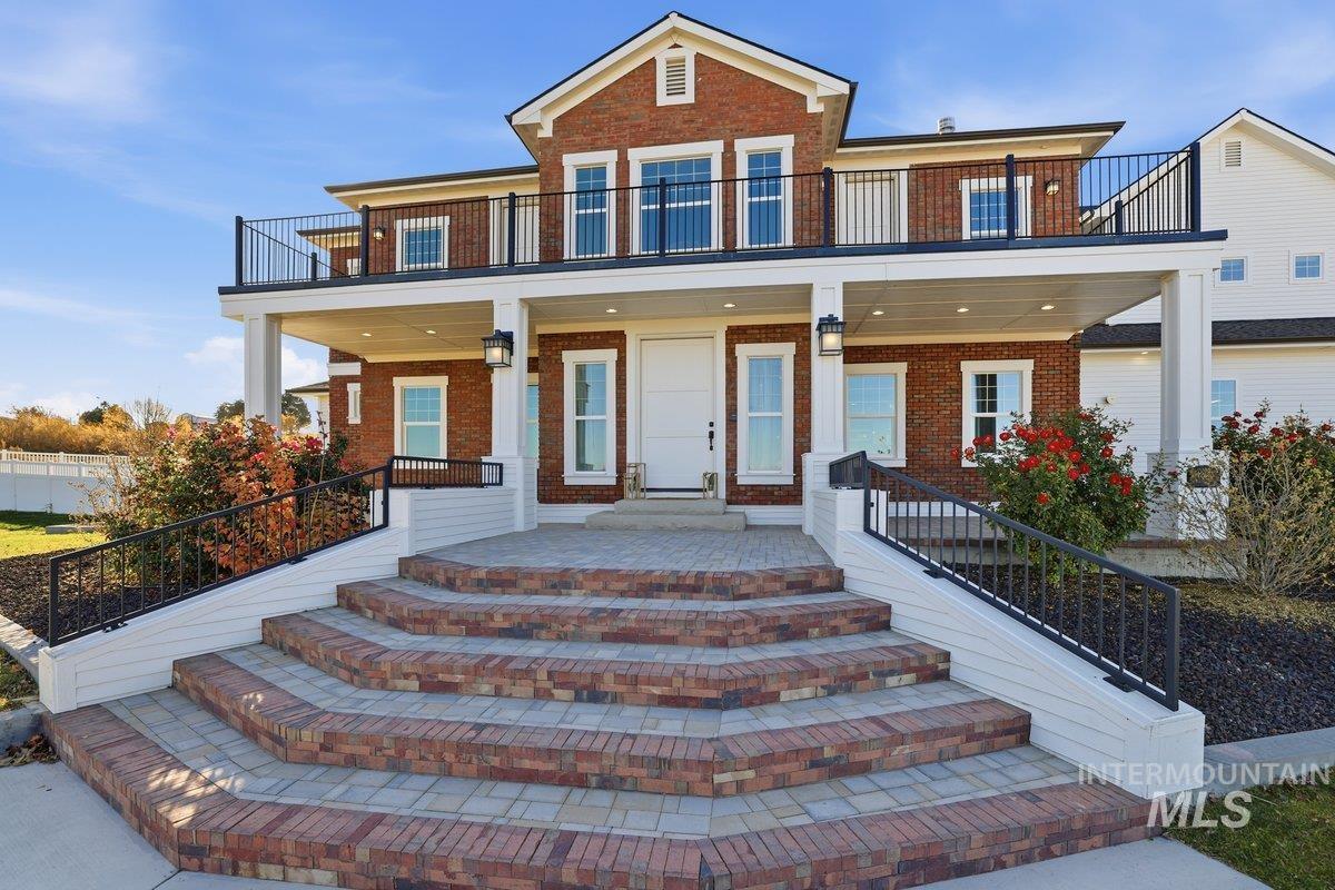 View of front of home with brick siding and a balcony