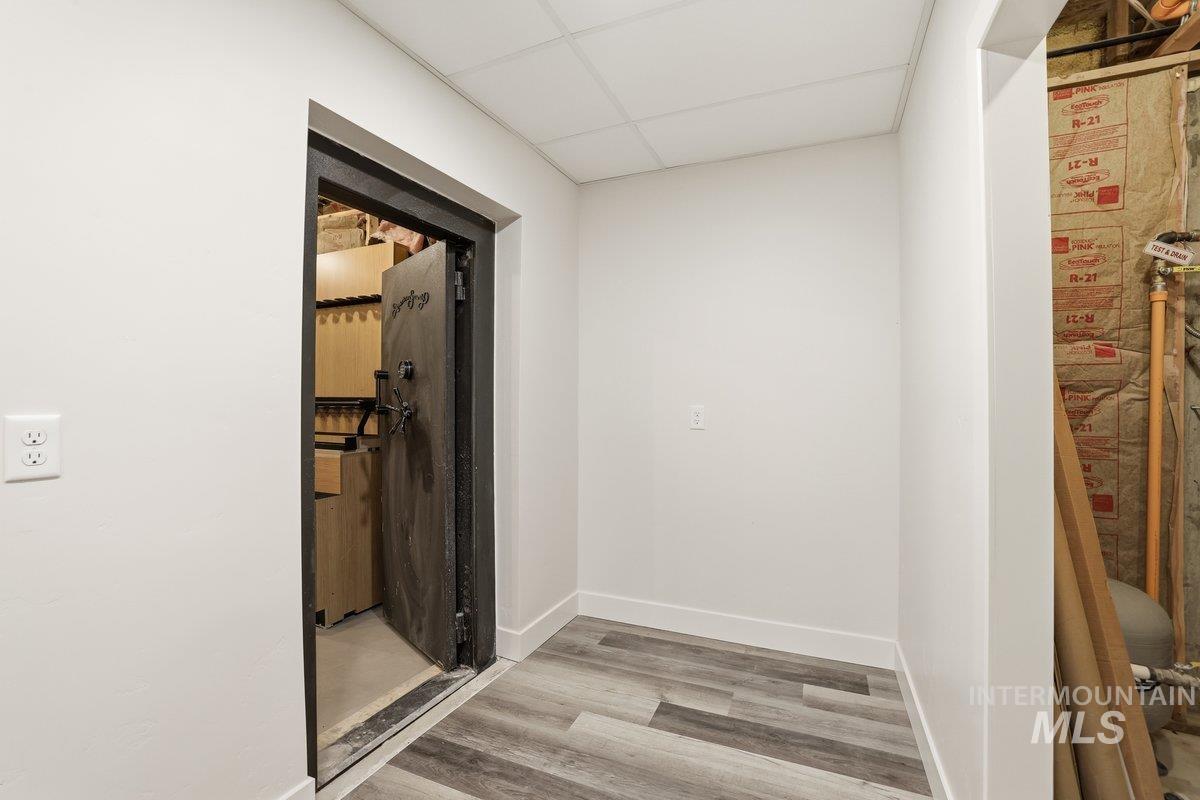 Hallway with light wood-type flooring and a paneled ceiling