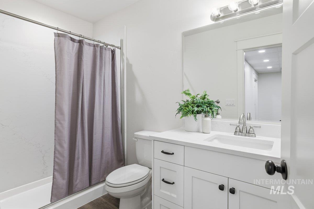 Full bath with a shower stall and vanity