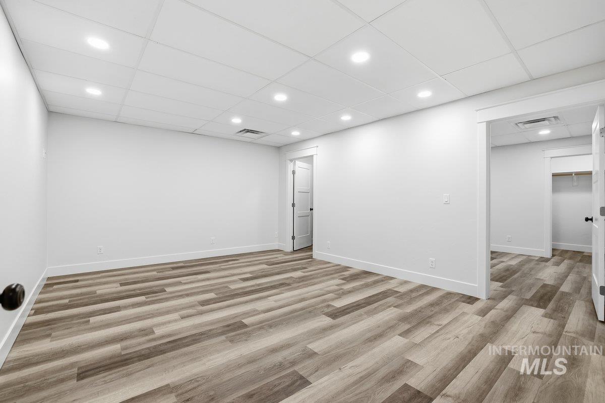 Spare room featuring a paneled ceiling, light wood finished floors, and recessed lighting