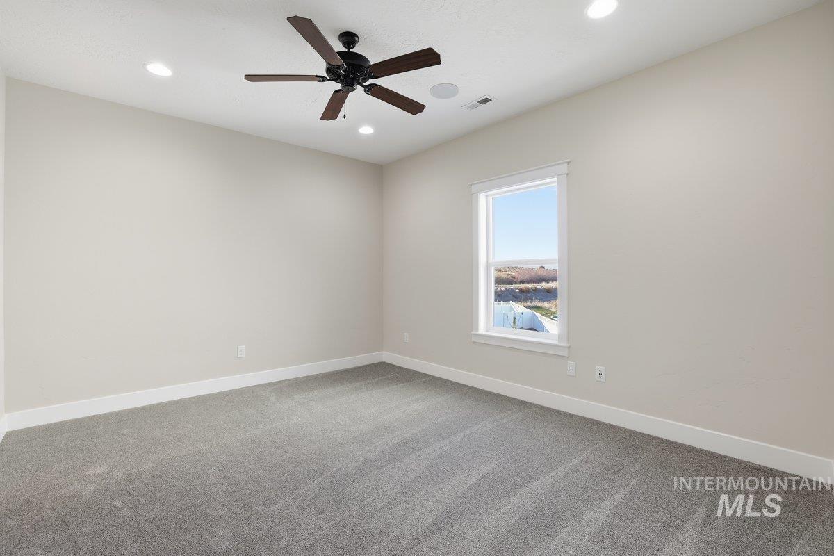 Spare room featuring light colored carpet, recessed lighting, and ceiling fan