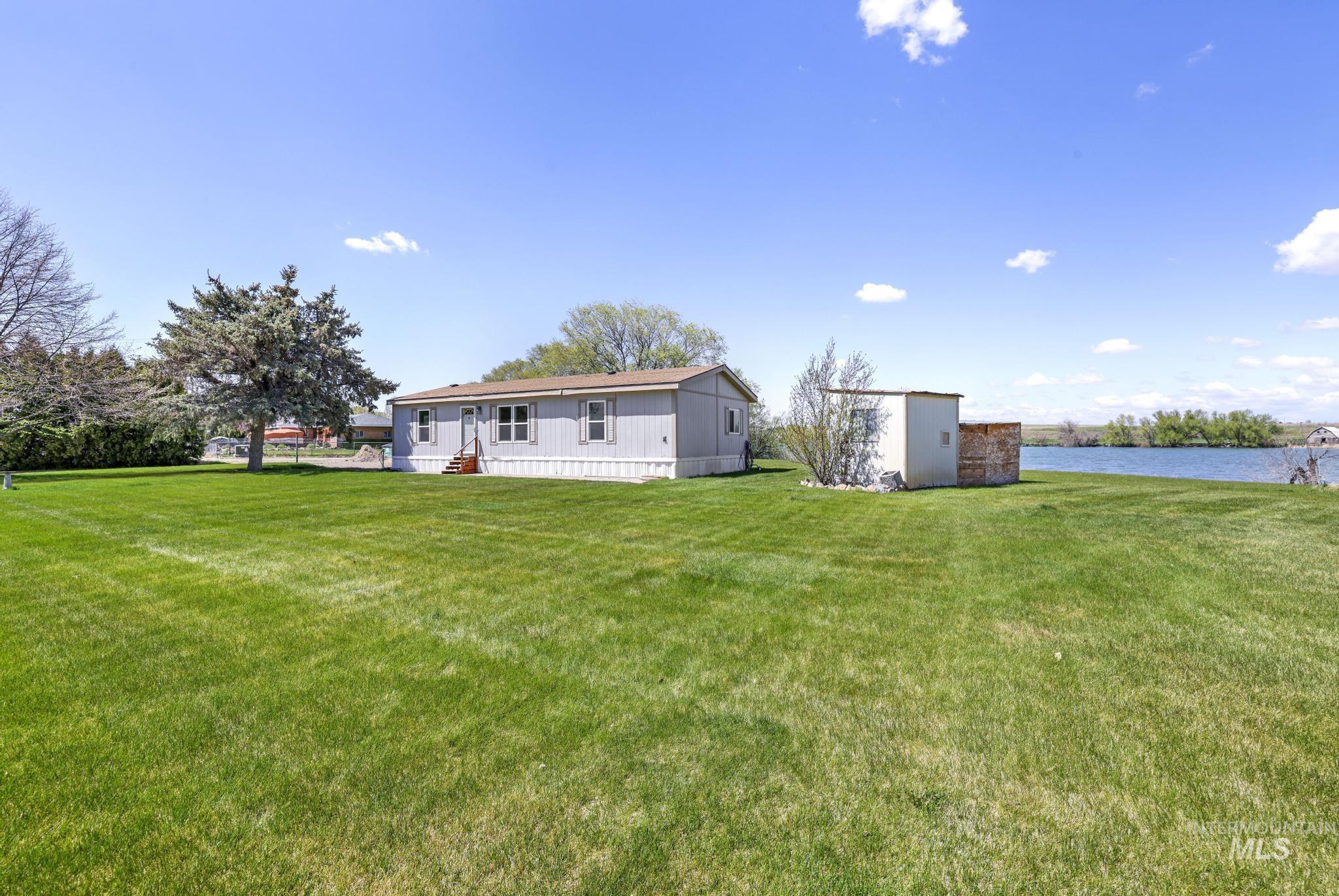 Back of house featuring a lawn and an outbuilding