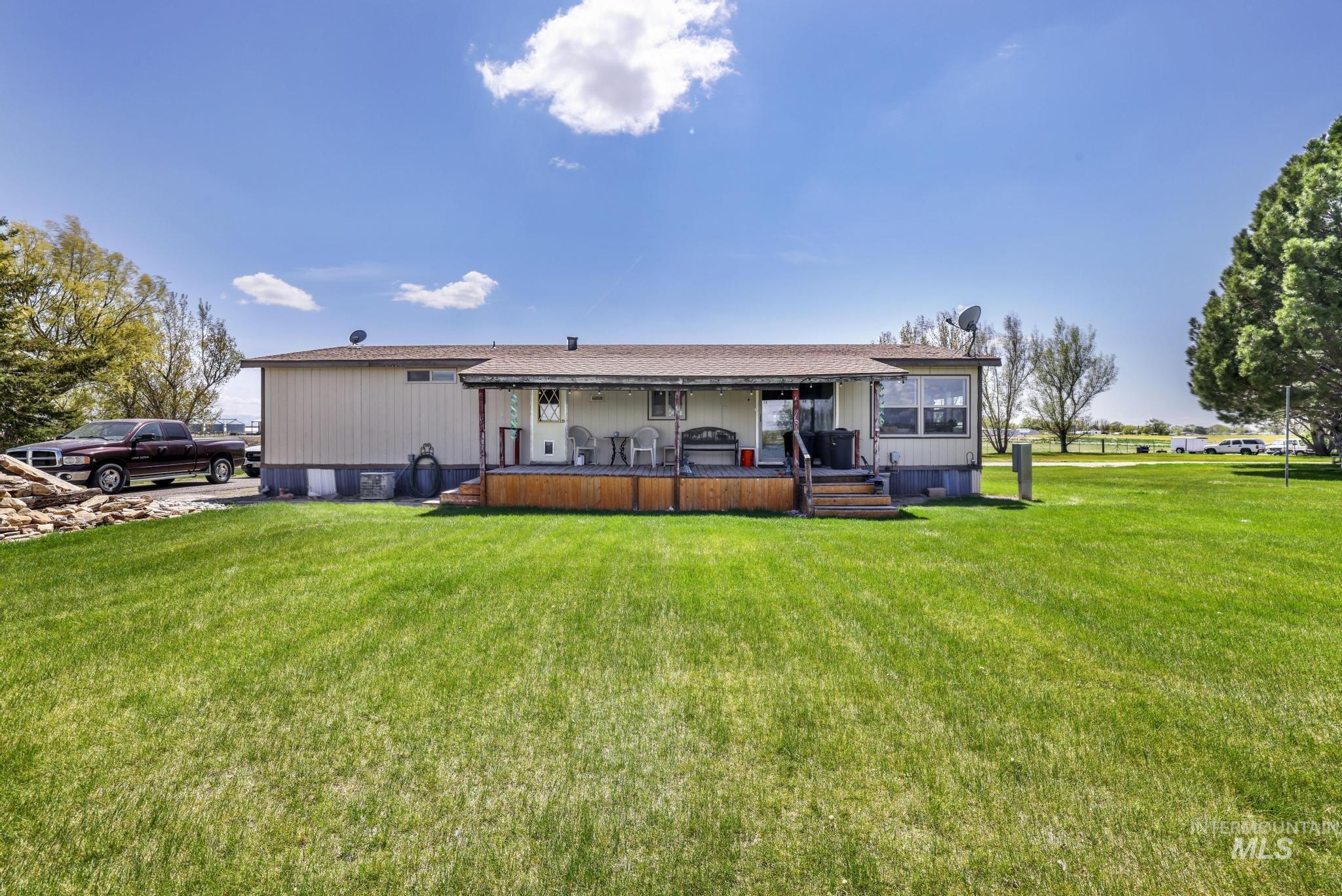 Rear view of property with a lawn and a wooden deck