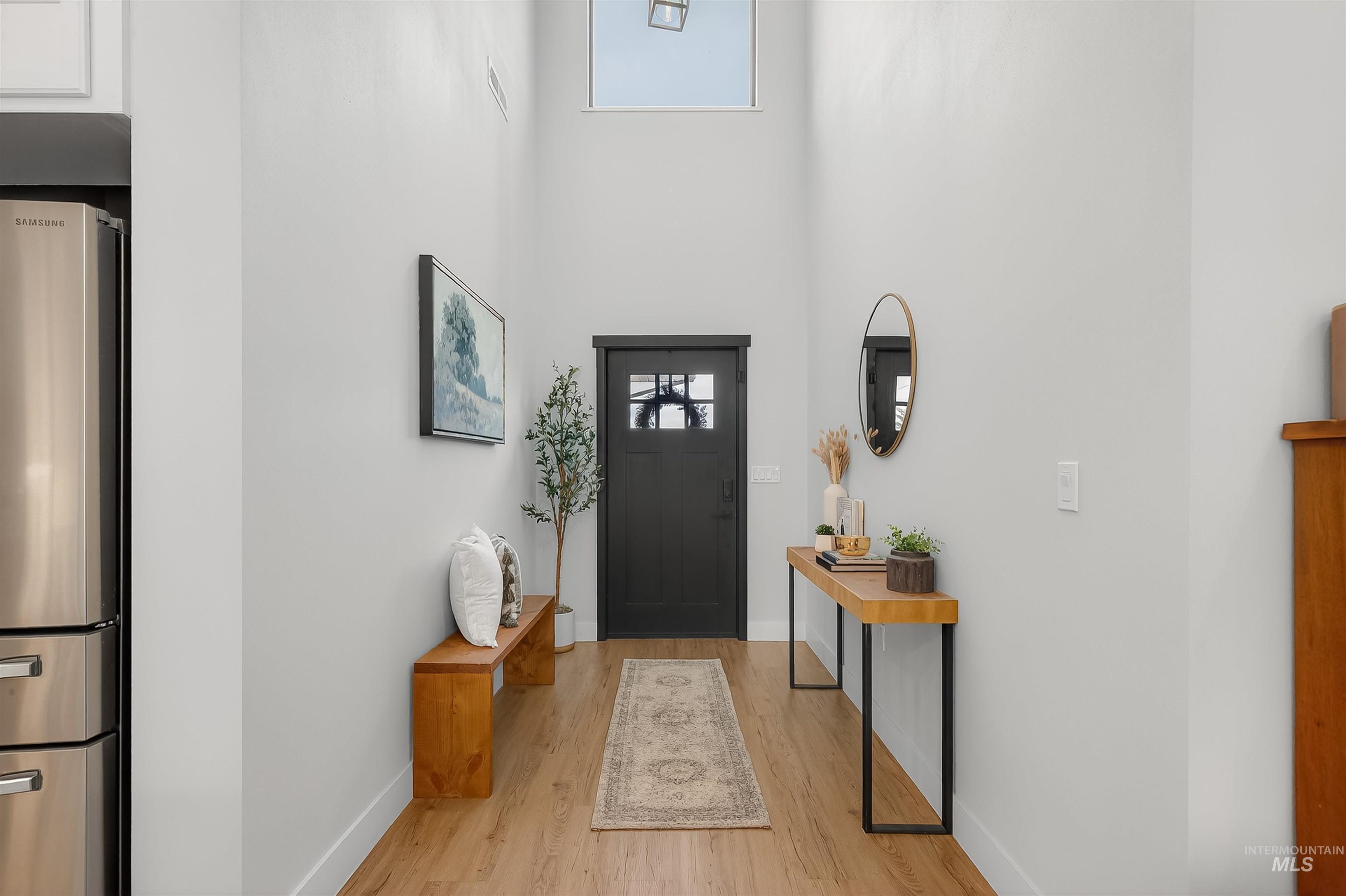 Foyer with a towering ceiling and light wood-type flooring