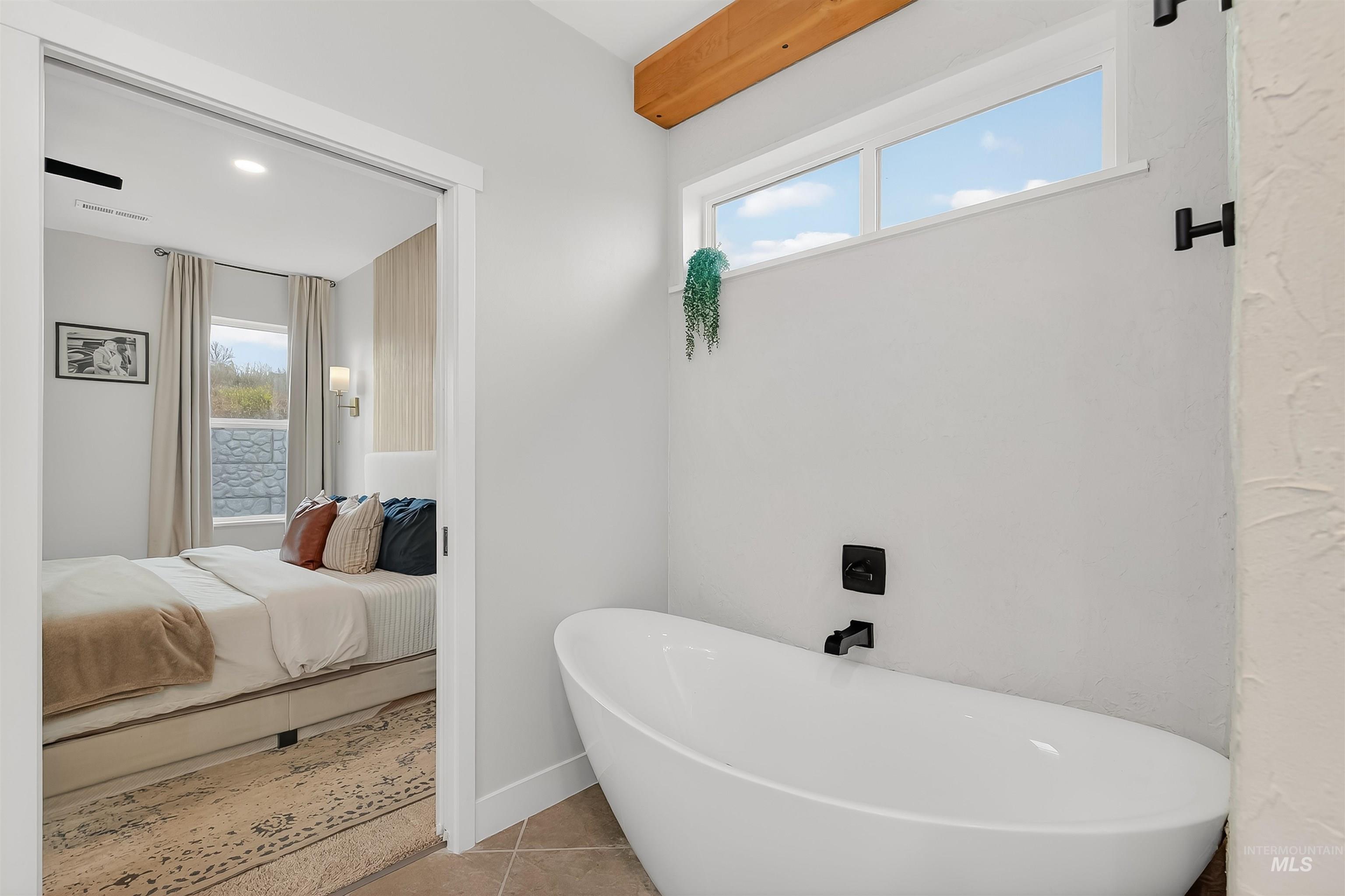 Full bathroom with a freestanding tub, connected bathroom, and tile patterned floors