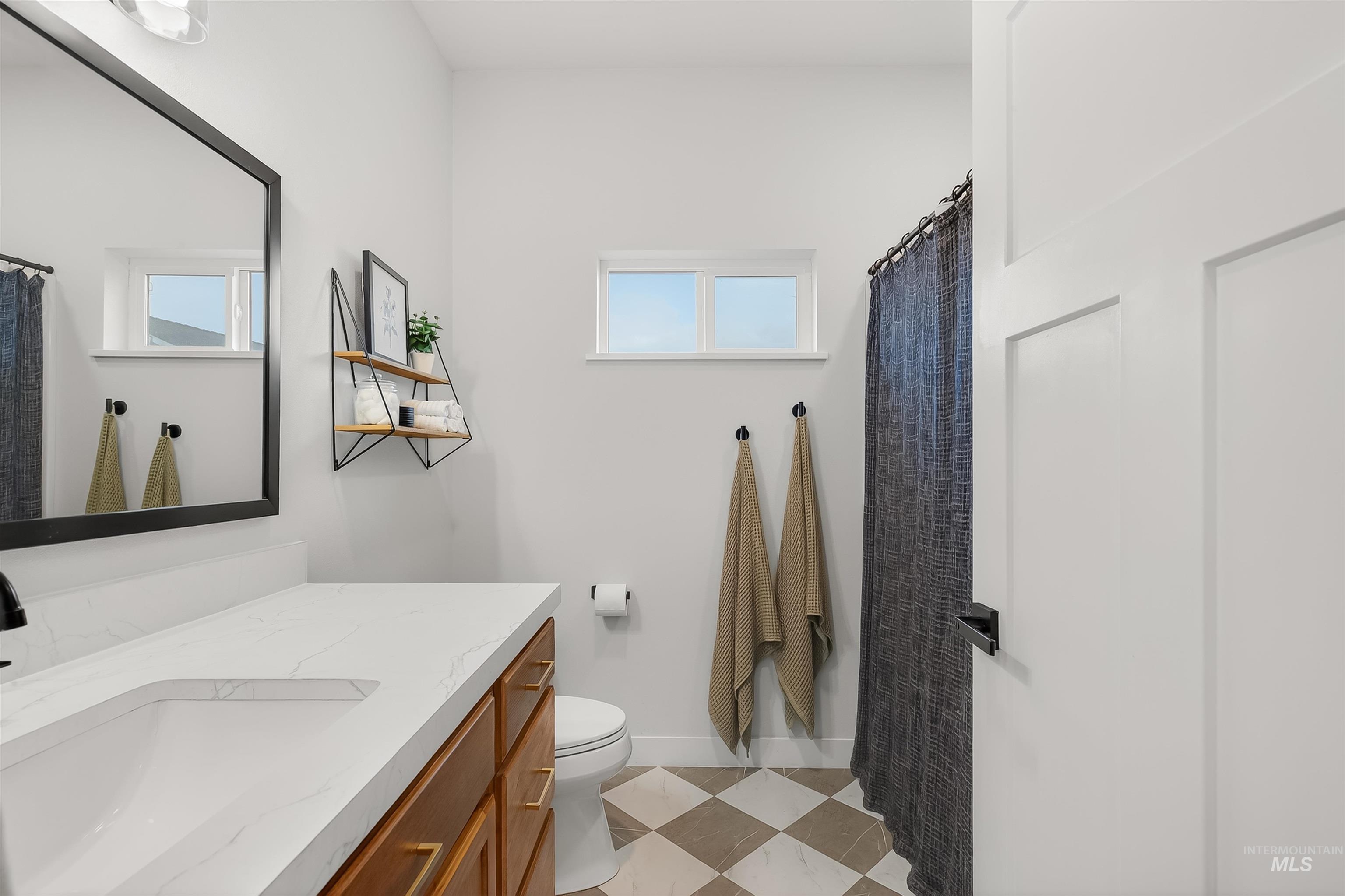 Bathroom featuring vanity, a shower with shower curtain, and light flooring