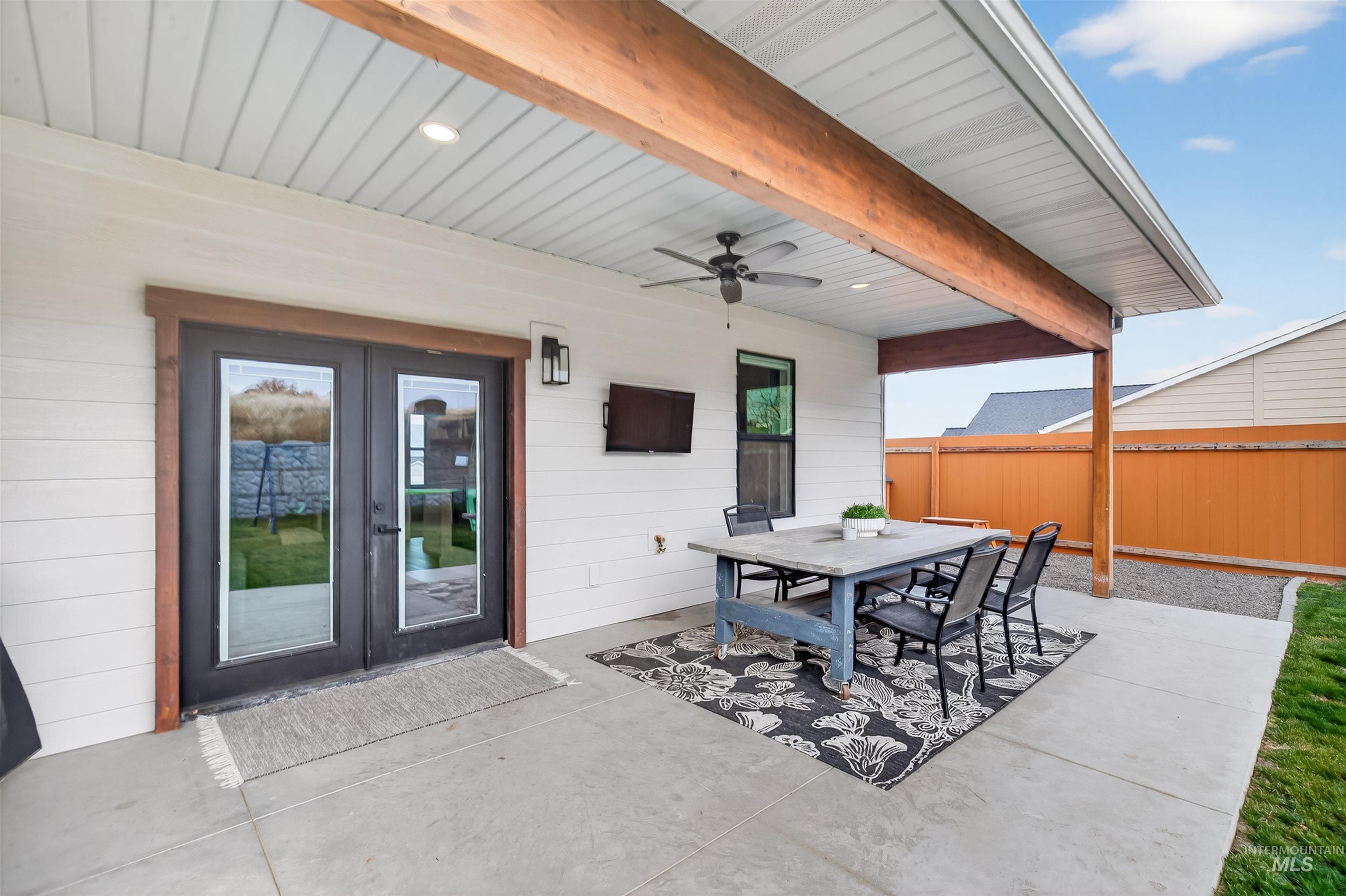View of patio featuring outdoor dining space, french doors, and a ceiling fan