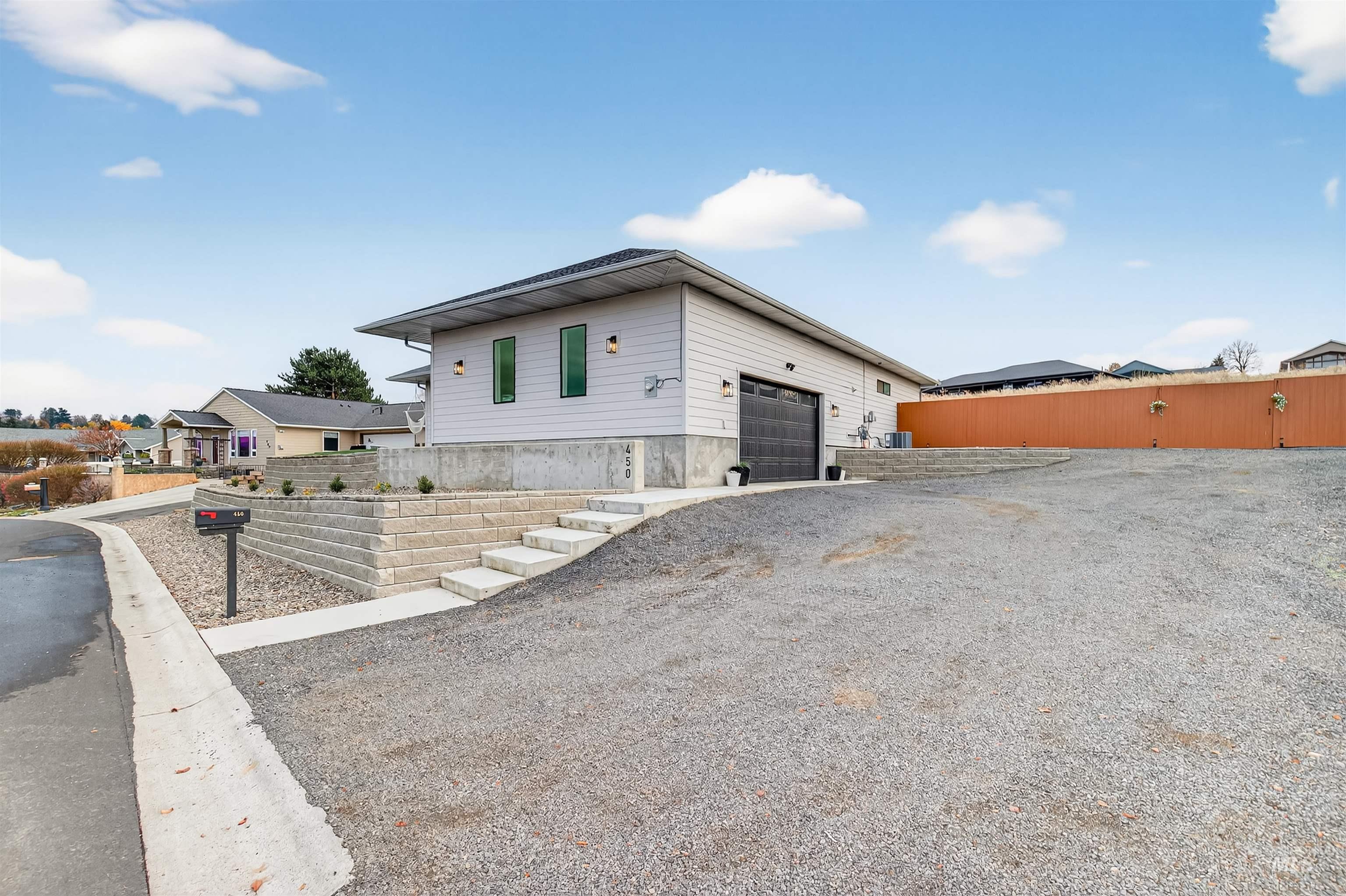 View of front of house featuring gravel driveway and an attached garage