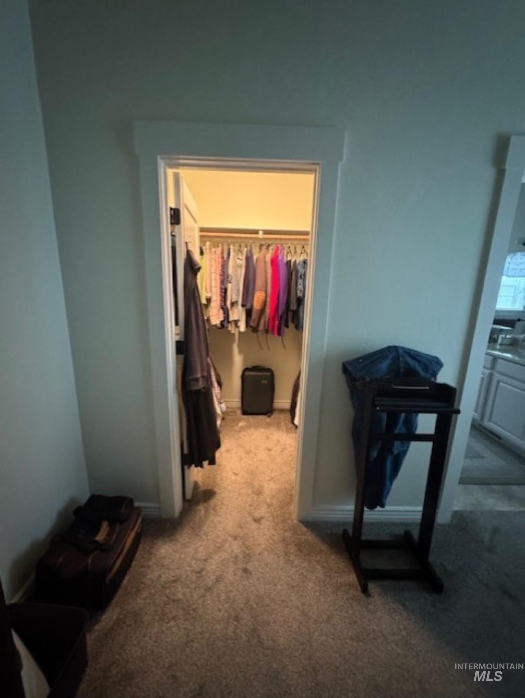 Hall with carpet flooring and baseboards