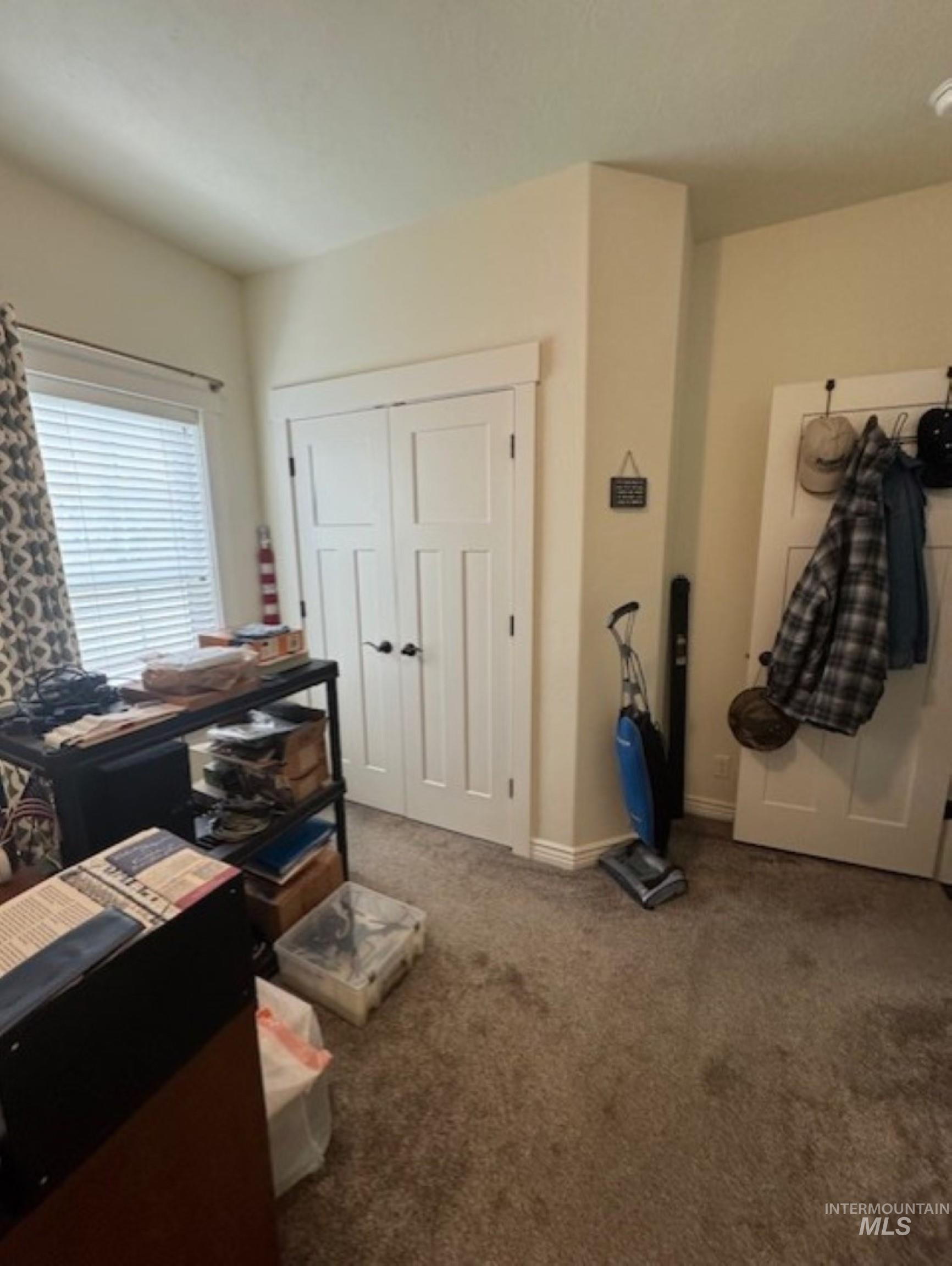Carpeted bedroom with baseboards and a closet