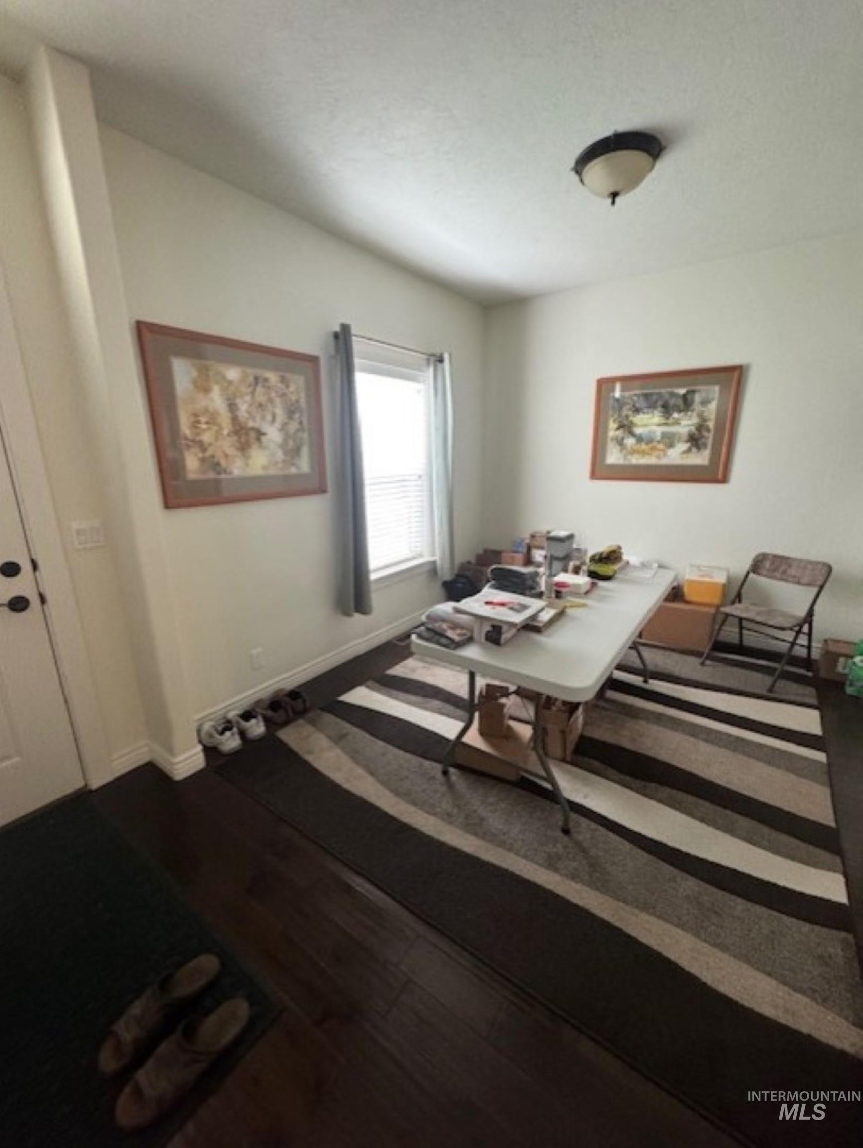 Dining room with dark wood-style floors and baseboards