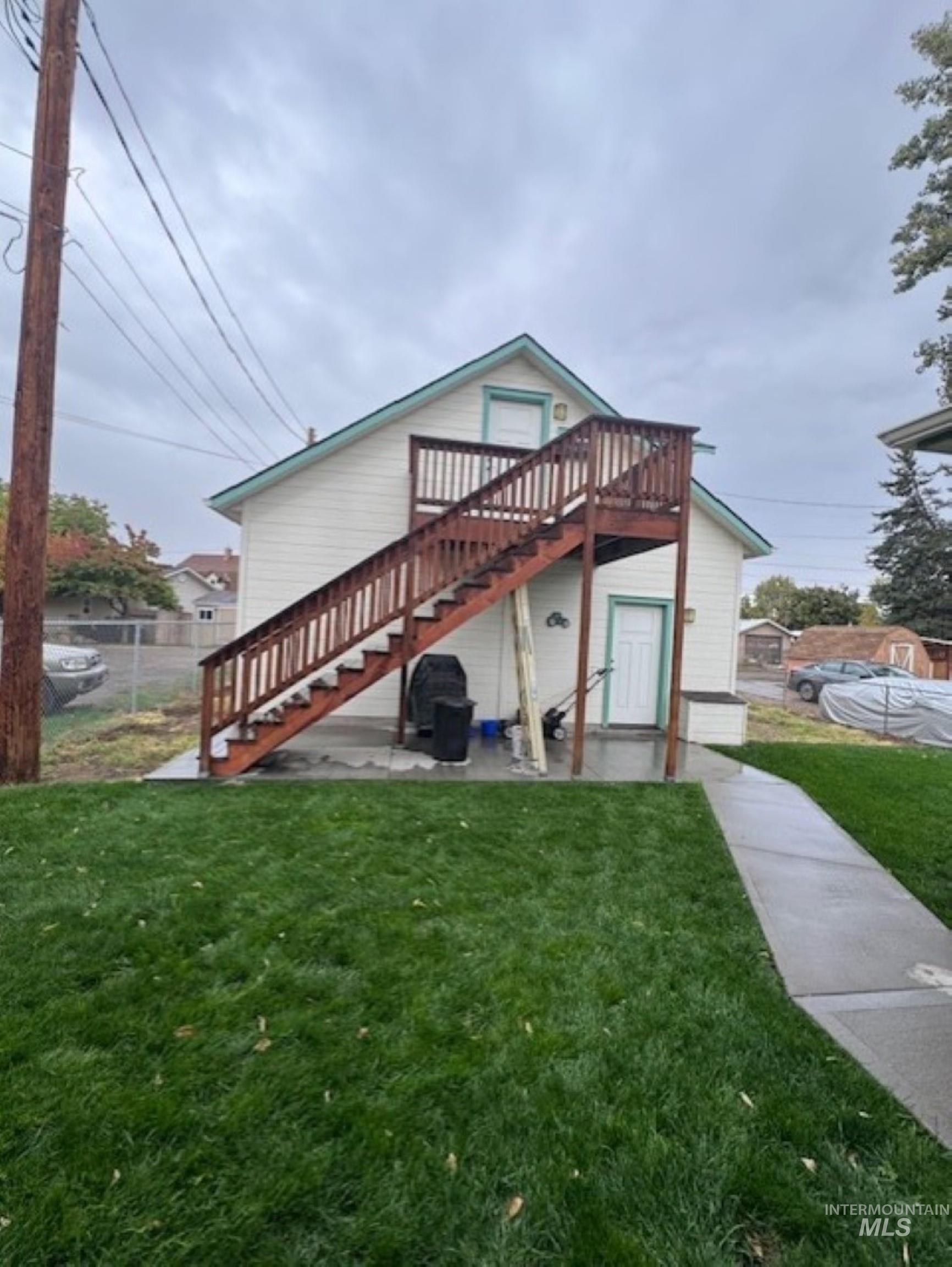 Back of house with stairway, a patio, and a wooden deck