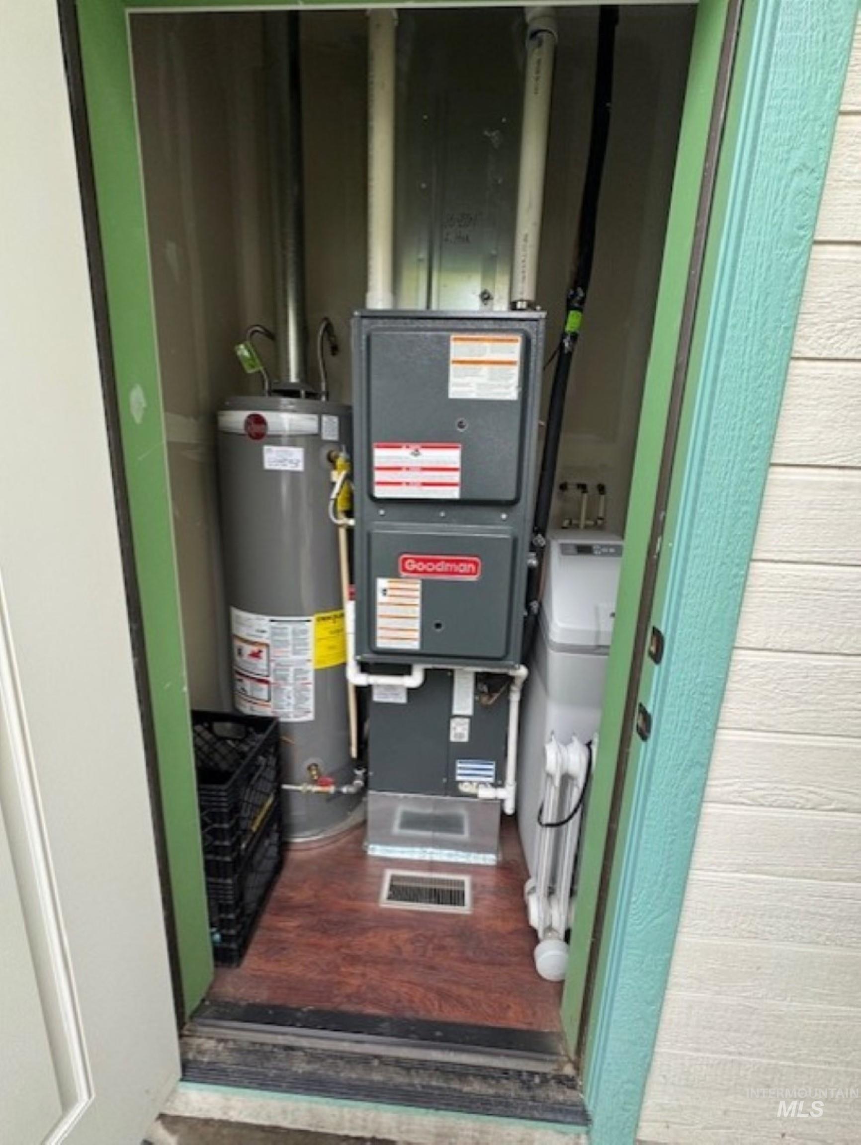 Utility room featuring water heater and heating unit