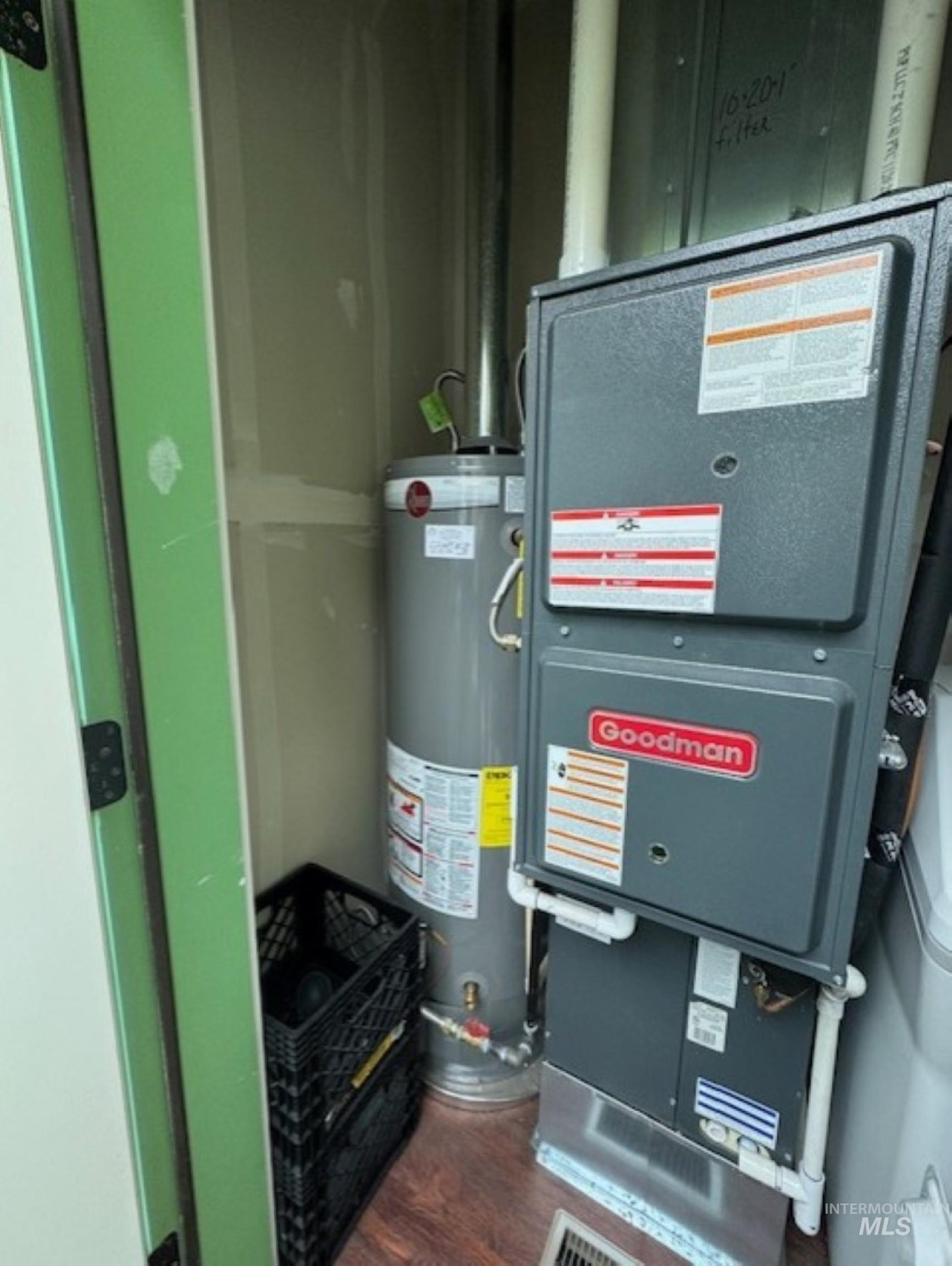 Utility room featuring heating unit and water heater