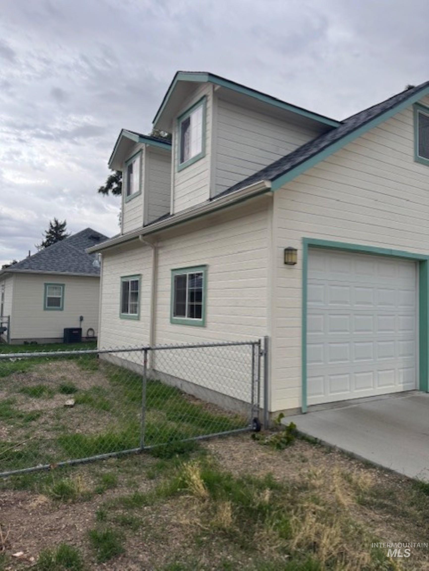View of side of home with an attached garage and driveway
