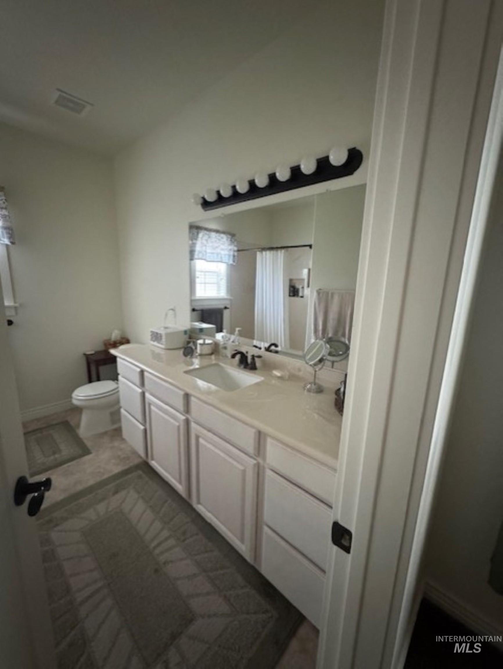 Full bath featuring vanity and curtained shower