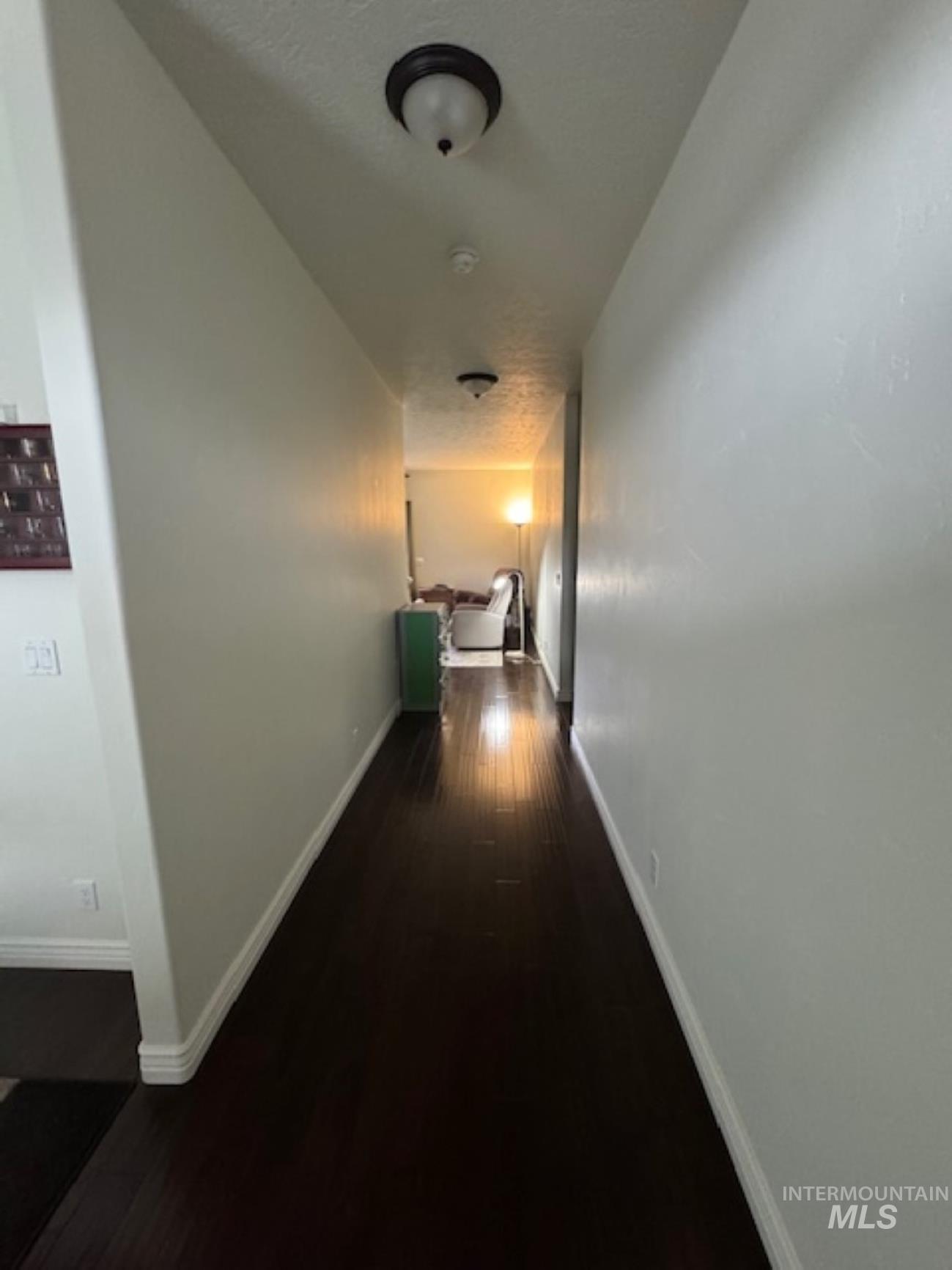 Hallway with dark wood finished floors and baseboards