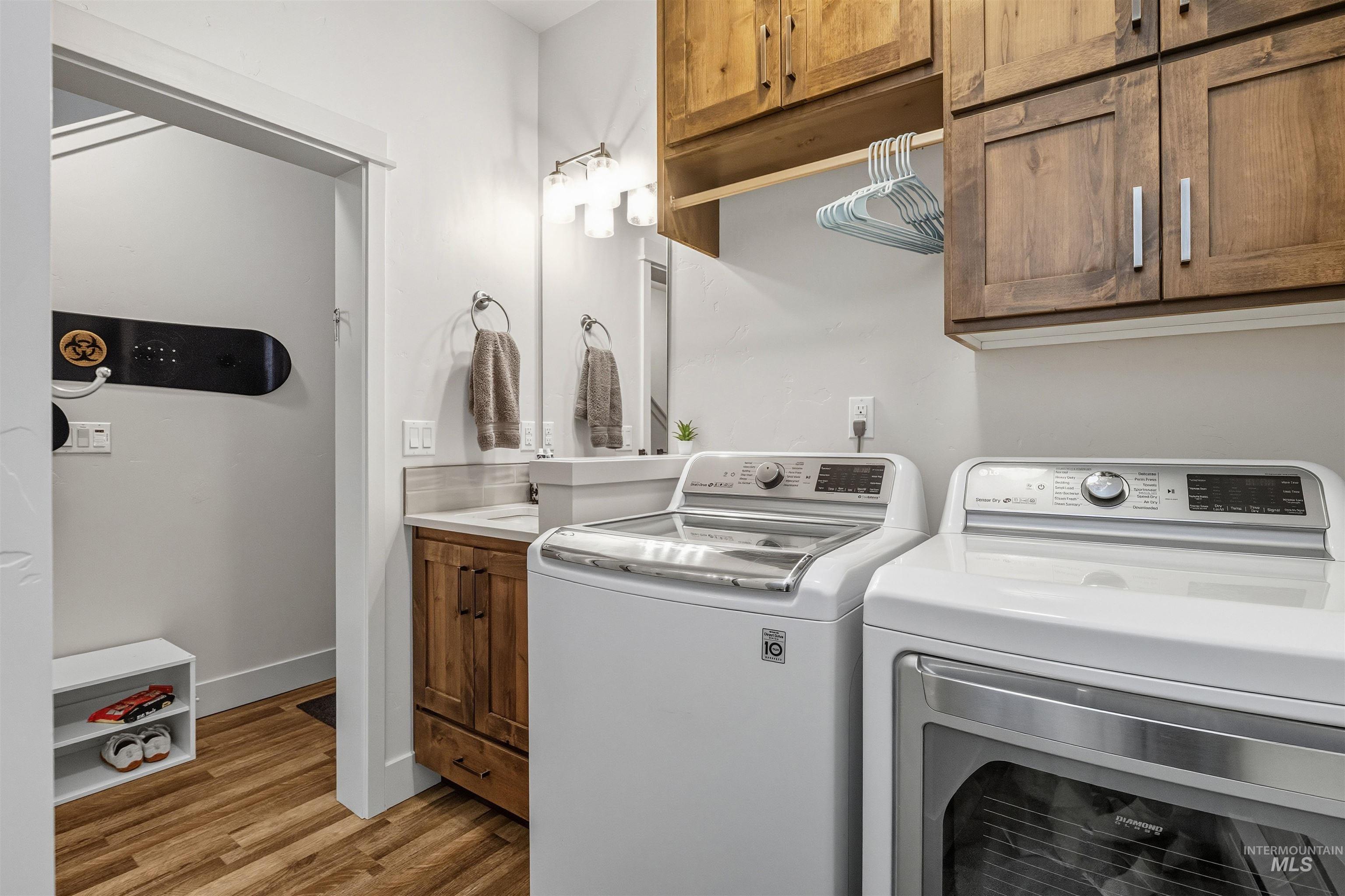 Laundry area with light wood-type flooring and washing machine and dryer