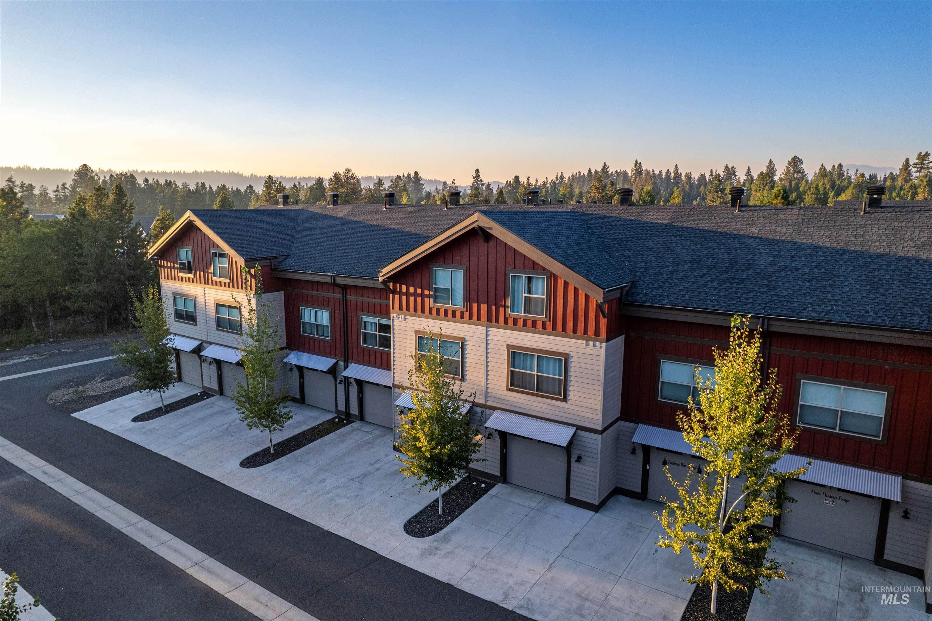 View of front of house featuring driveway, board and batten siding, an attached garage, and roof with shingles