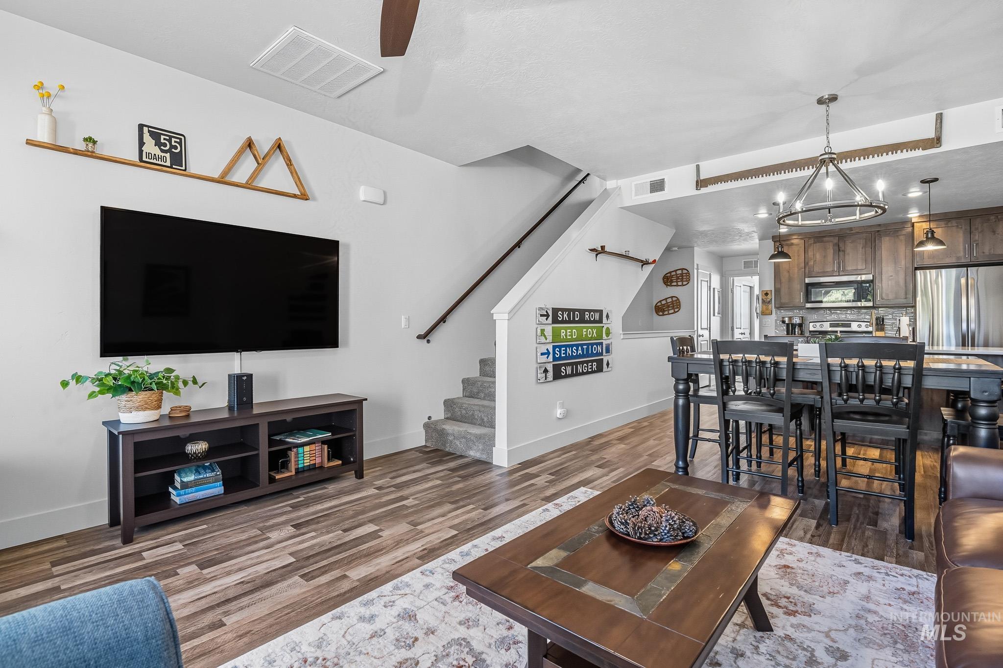 Living area featuring stairs, light wood-style flooring, recessed lighting, and a chandelier