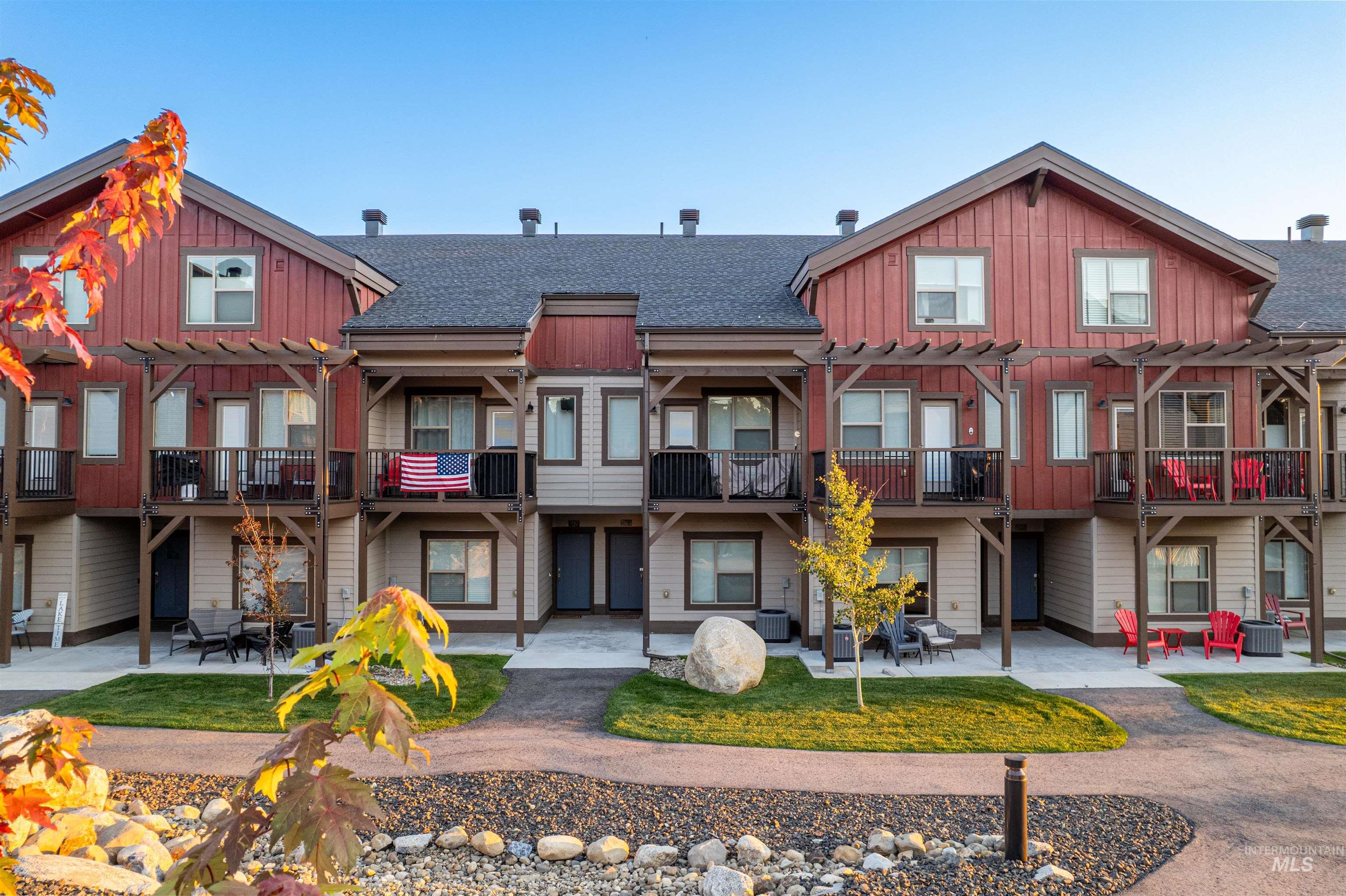 Back of house featuring a shingled roof, board and batten siding, a patio, and a balcony