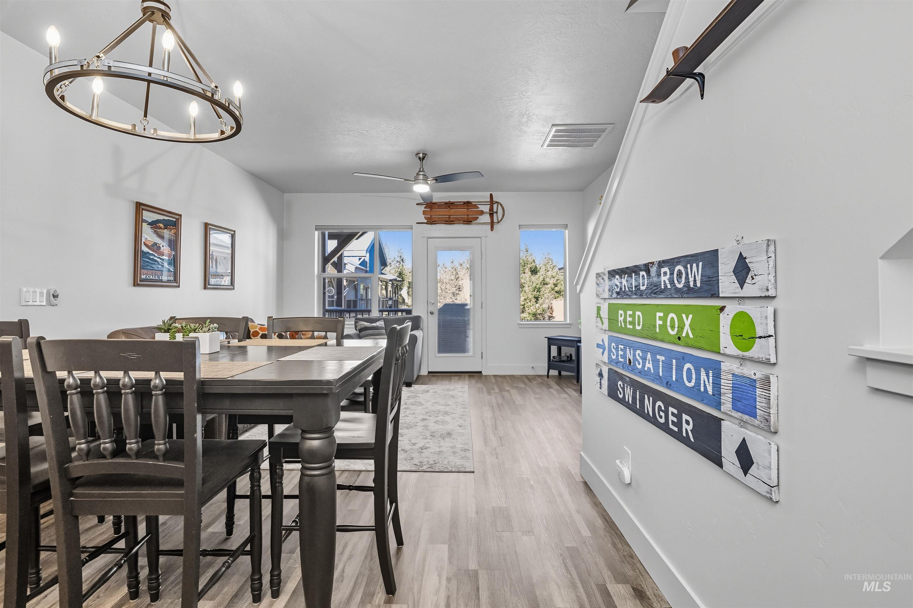 Dining room featuring wood finished floors, ceiling fan, and a chandelier
