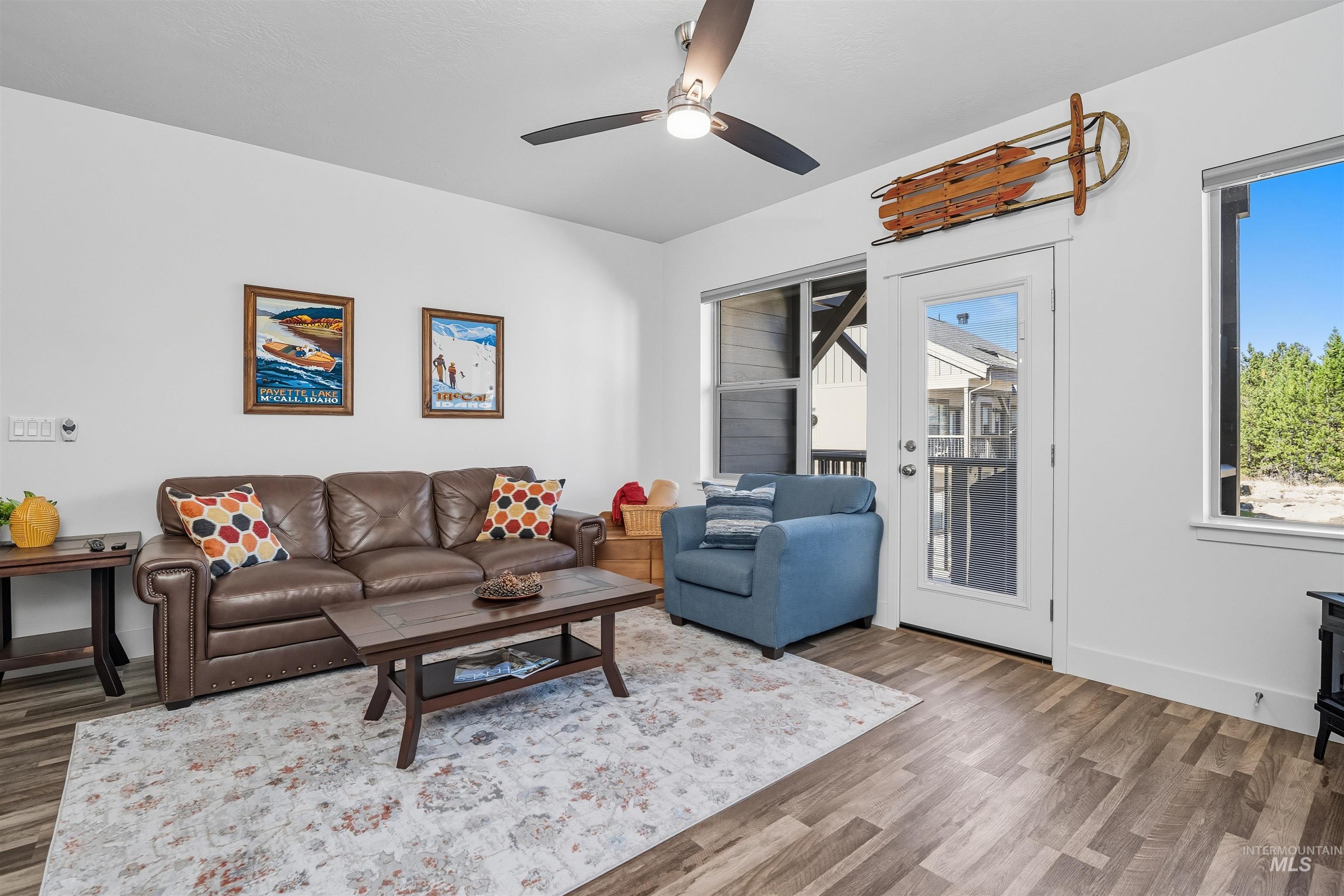 Living room featuring healthy amount of natural light, wood finished floors, and a wood stove