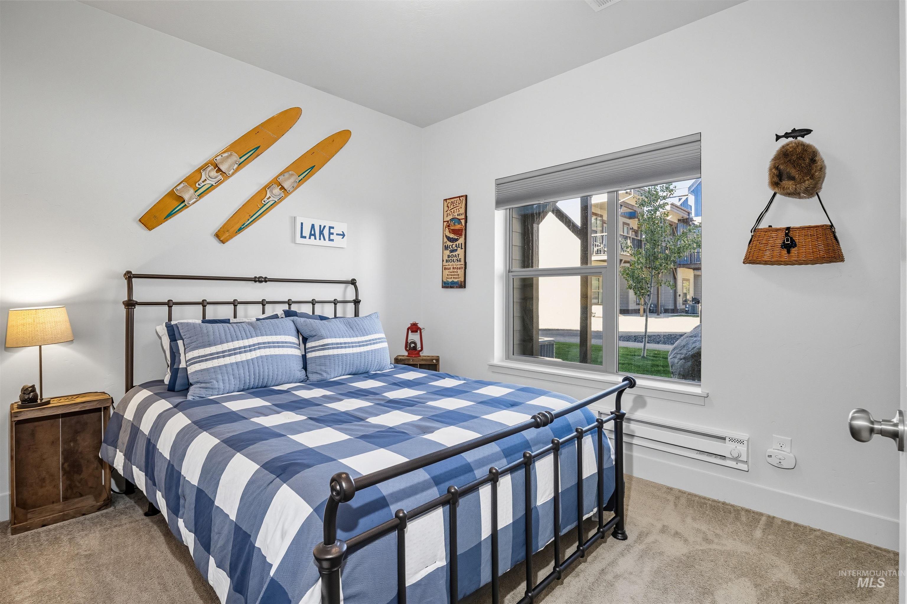 Bedroom featuring light carpet and baseboard heating