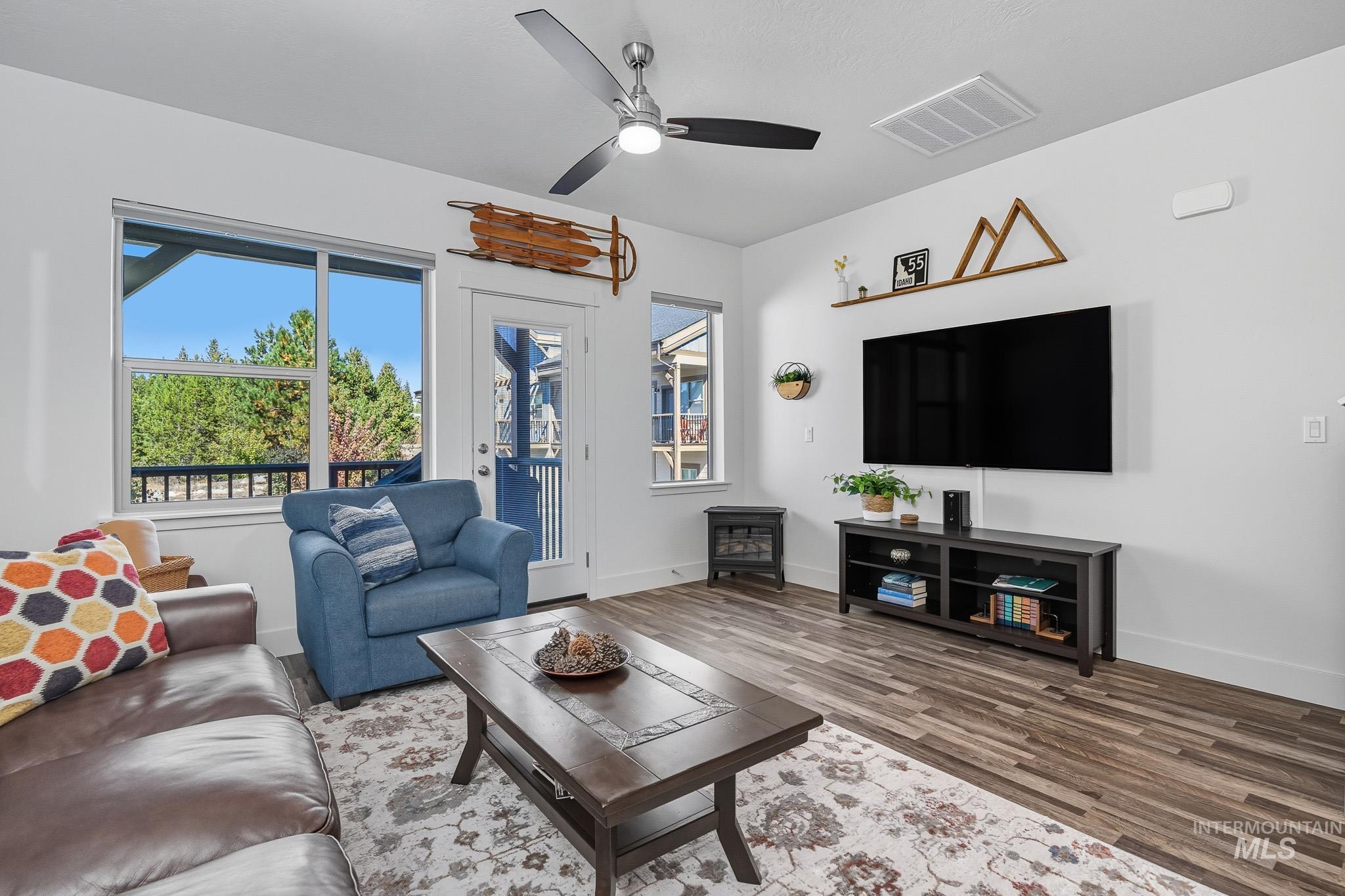 Living room featuring ceiling fan and wood finished floors