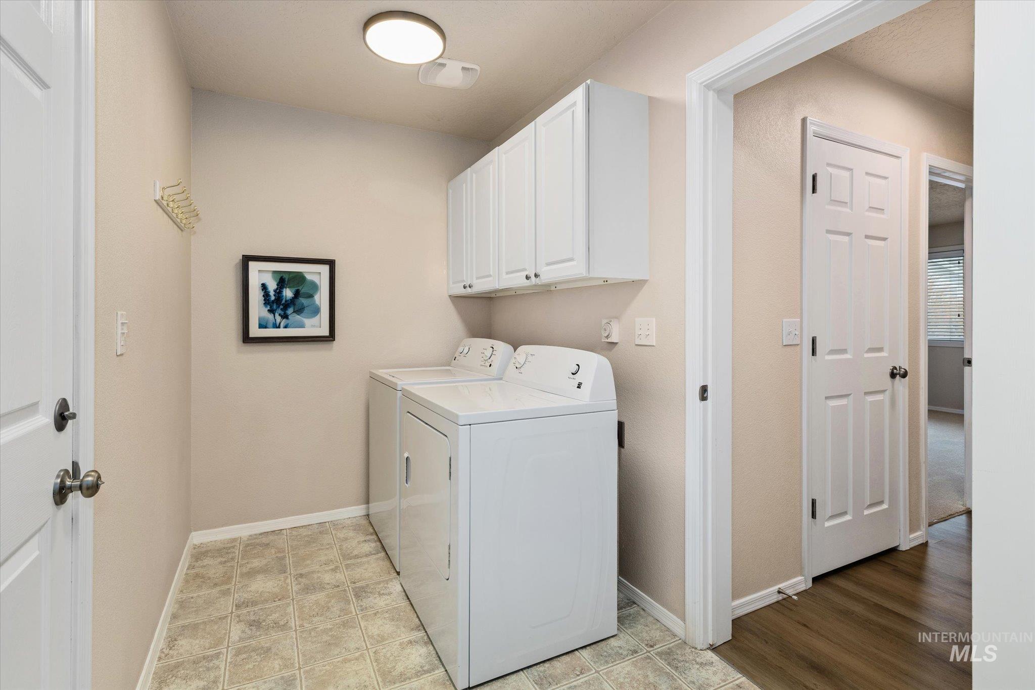 Laundry area featuring cabinet space and washing machine and clothes dryer
