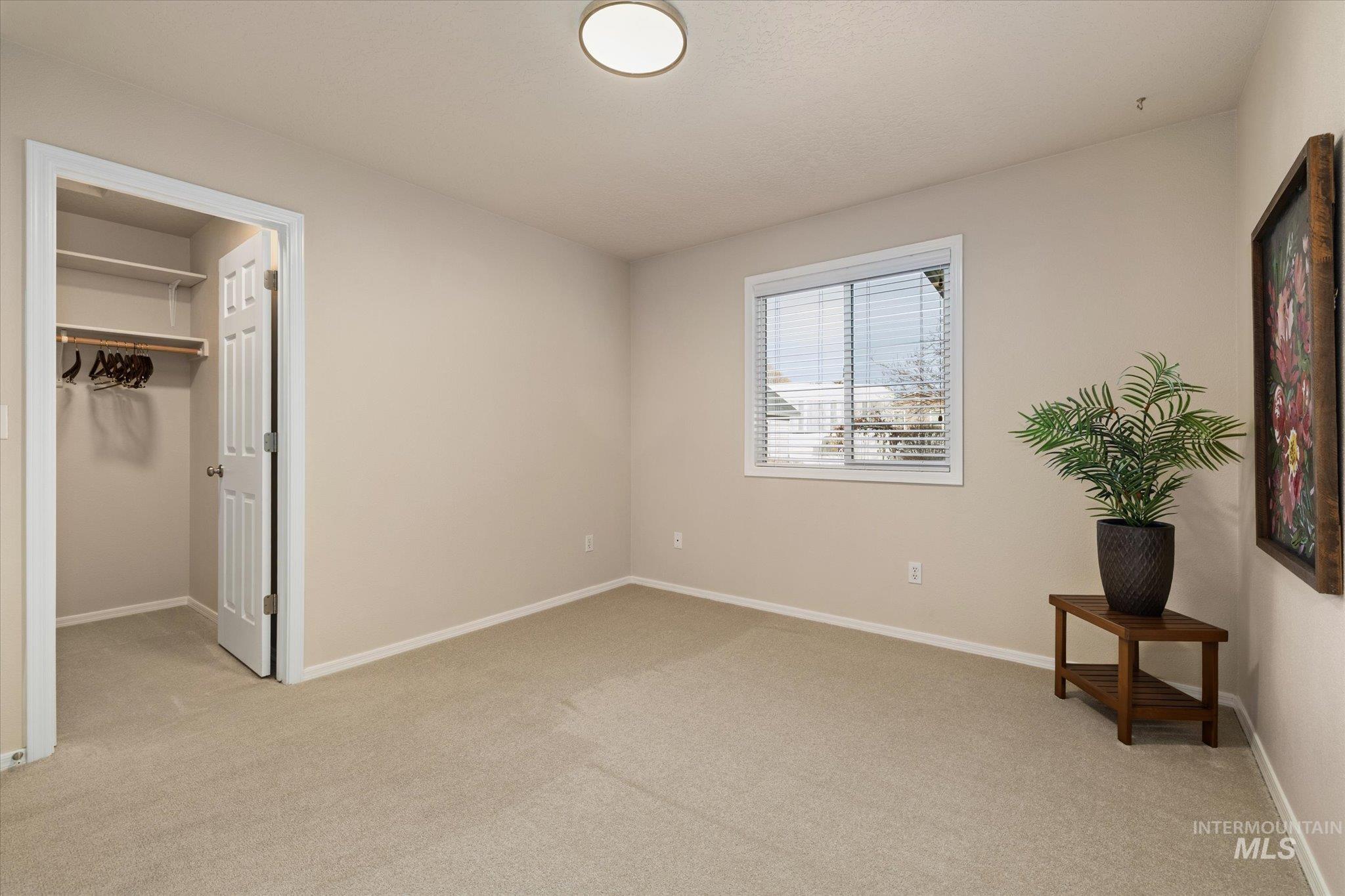 Unfurnished bedroom featuring a spacious closet and light colored carpet
