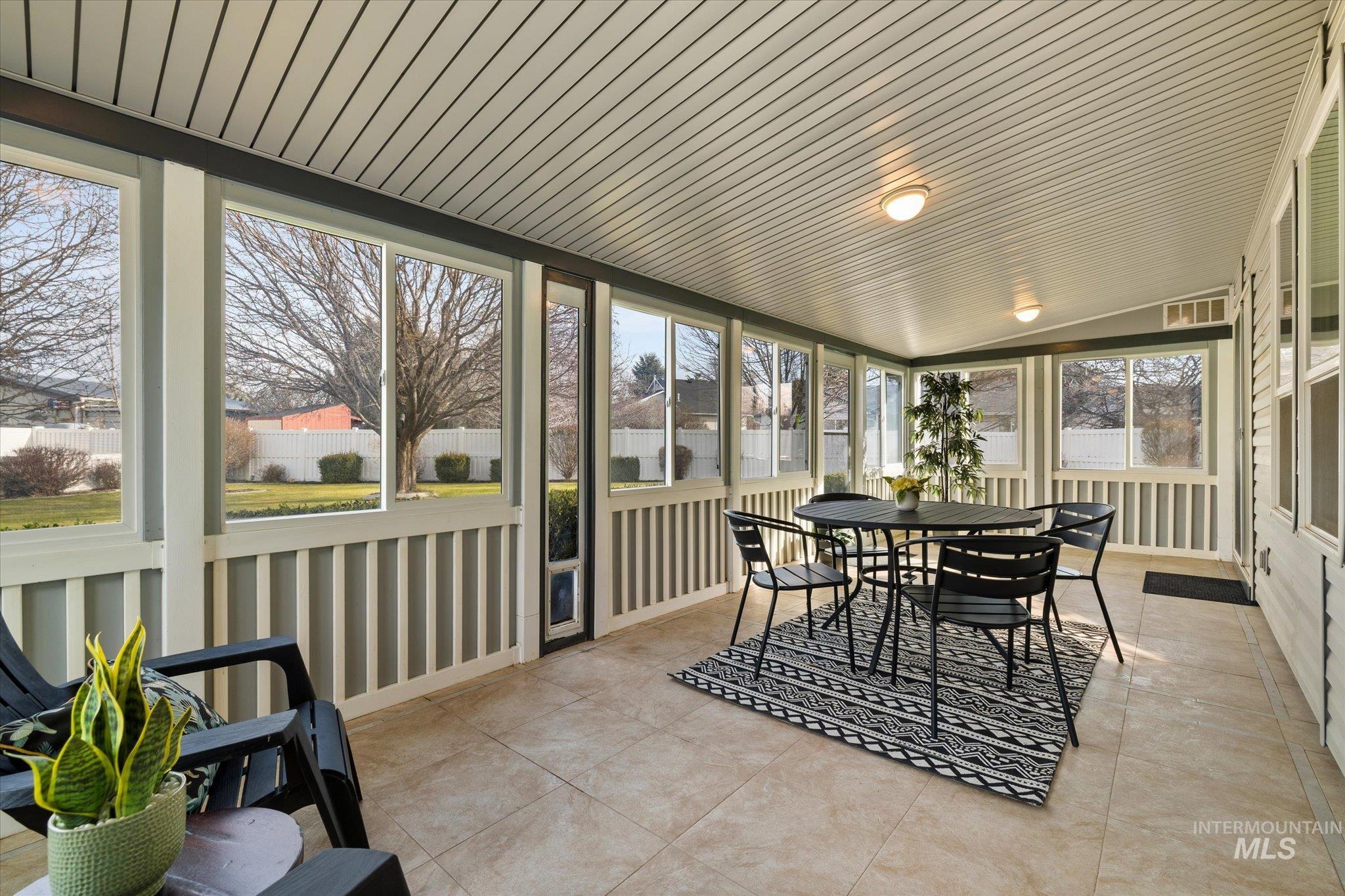 Sunroom with vaulted ceiling and outdoor dining space