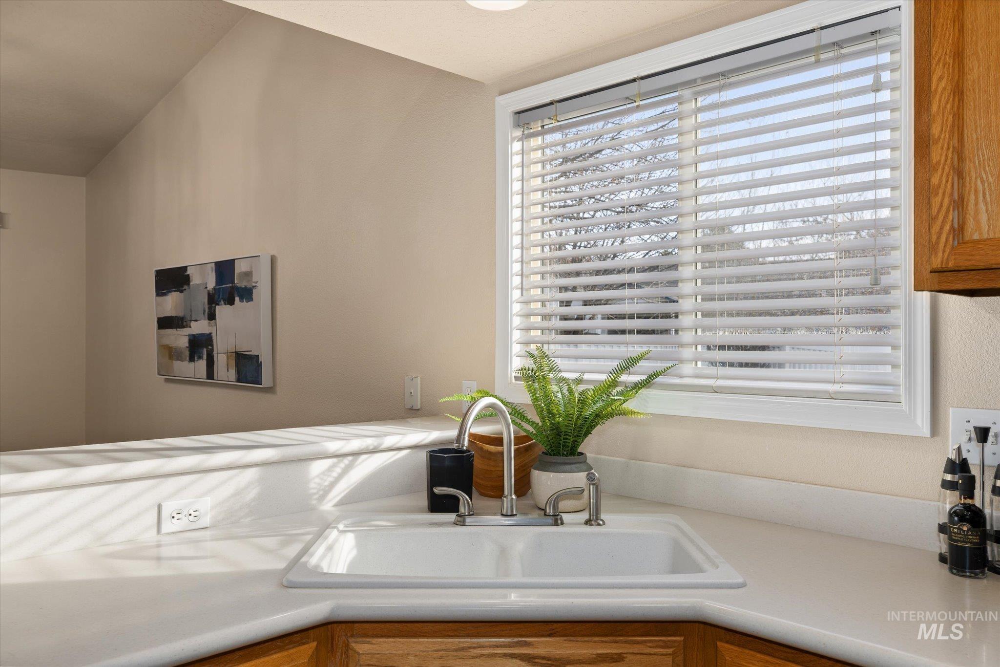 Kitchen view of light countertops and brown cabinetry