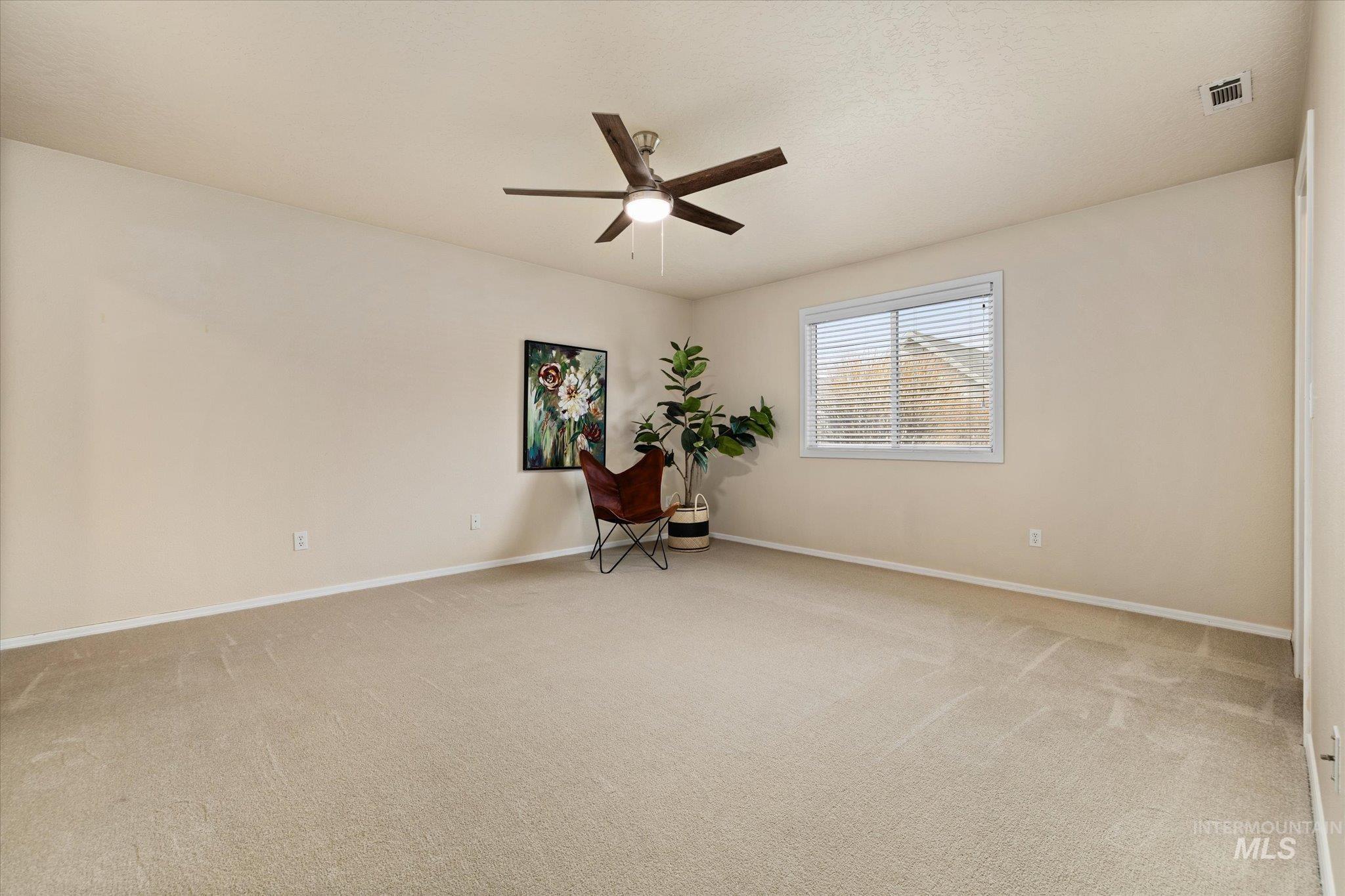 Unfurnished room with light colored carpet and a ceiling fan
