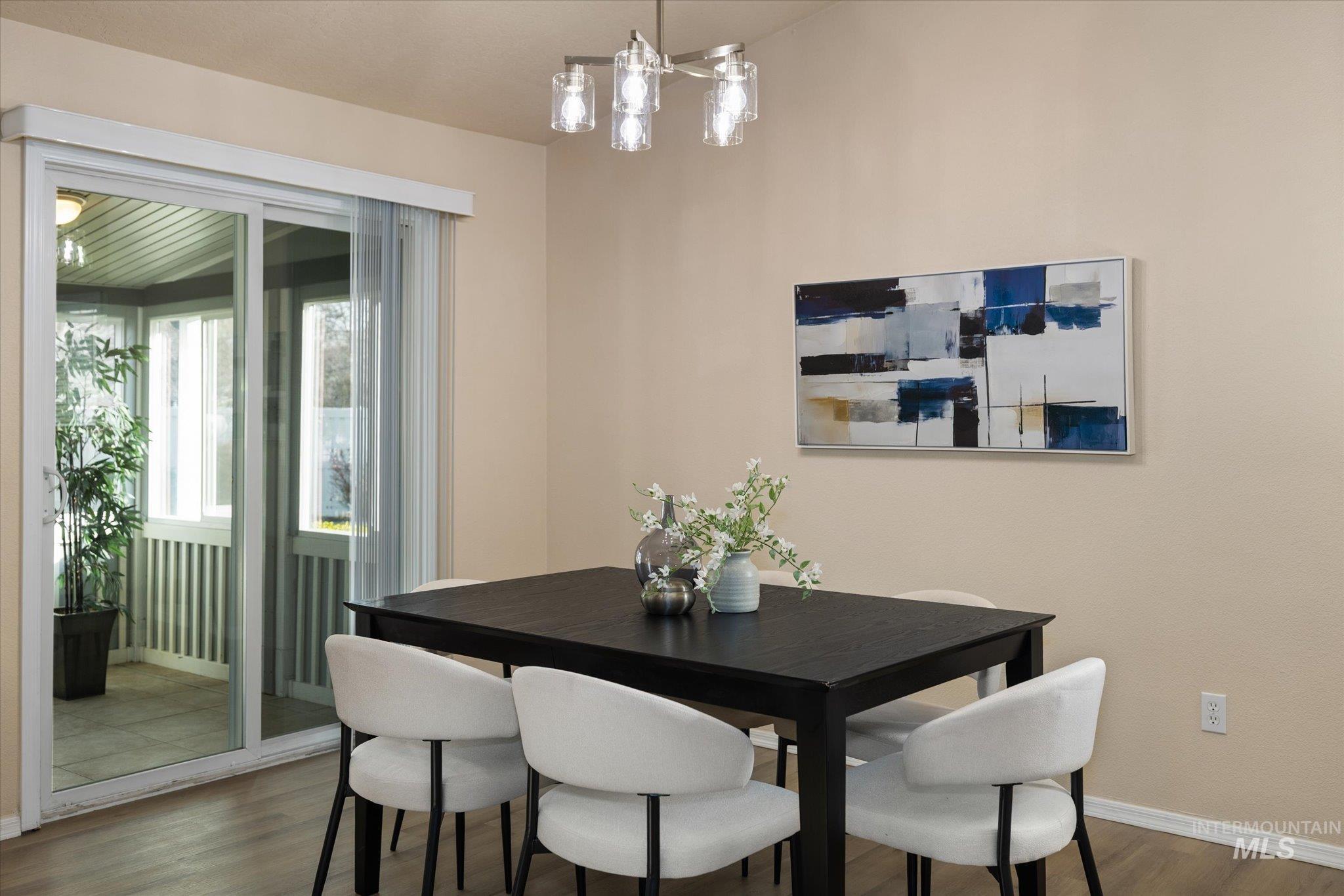 Dining space with wood finished floors and a chandelier