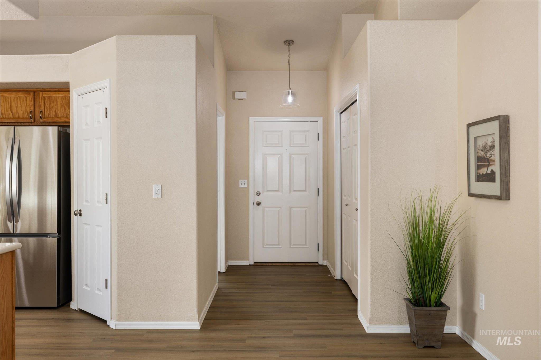 Entrance foyer featuring dark wood-style flooring and baseboards