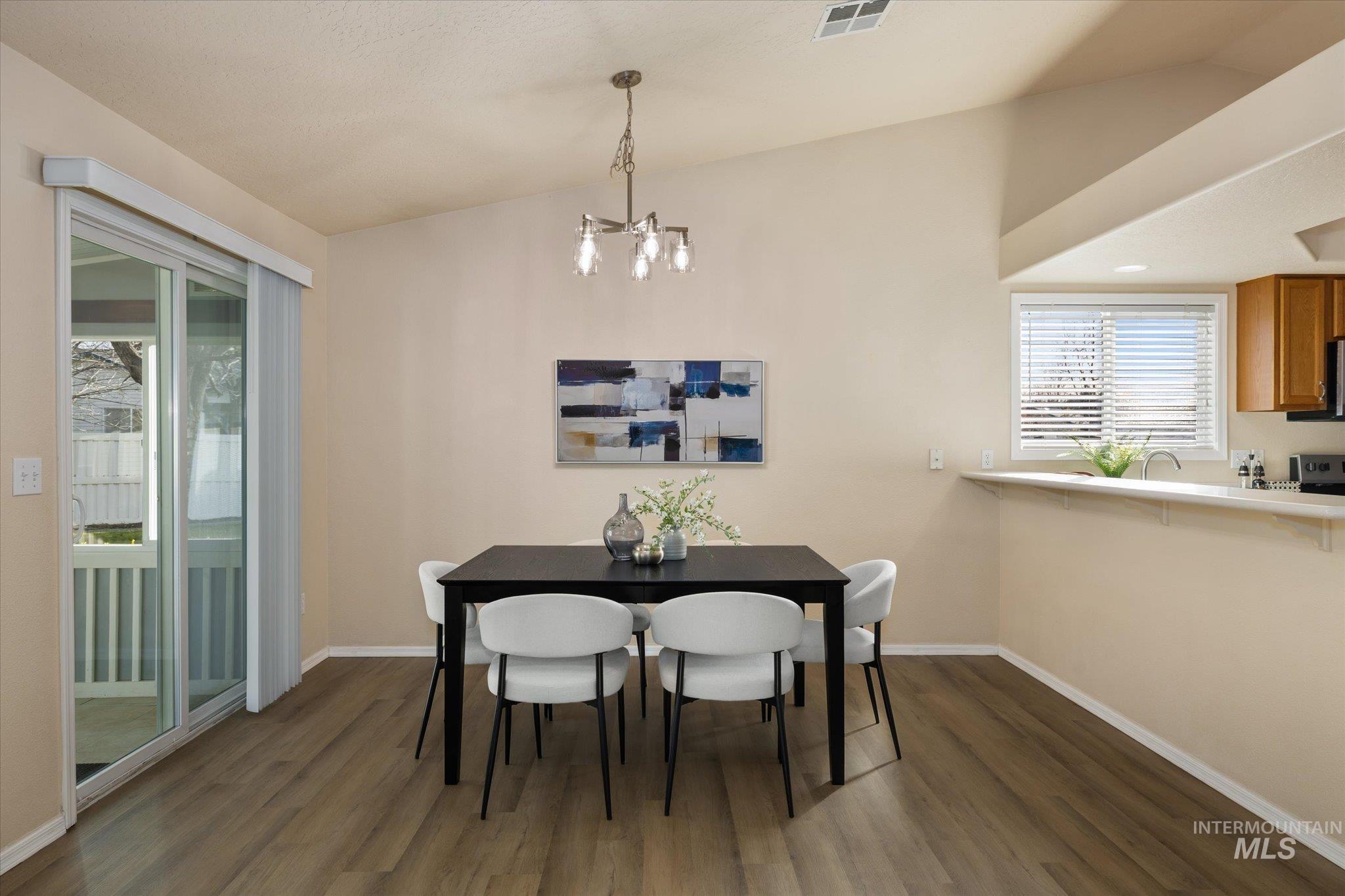 Dining room featuring lofted ceiling and dark wood-style floors