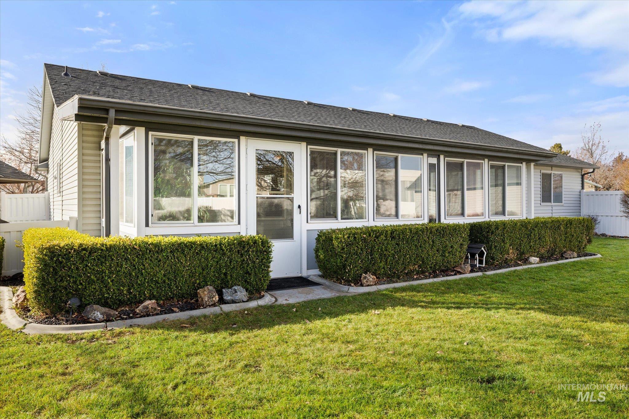 View of front of property with roof with shingles and a sunroom