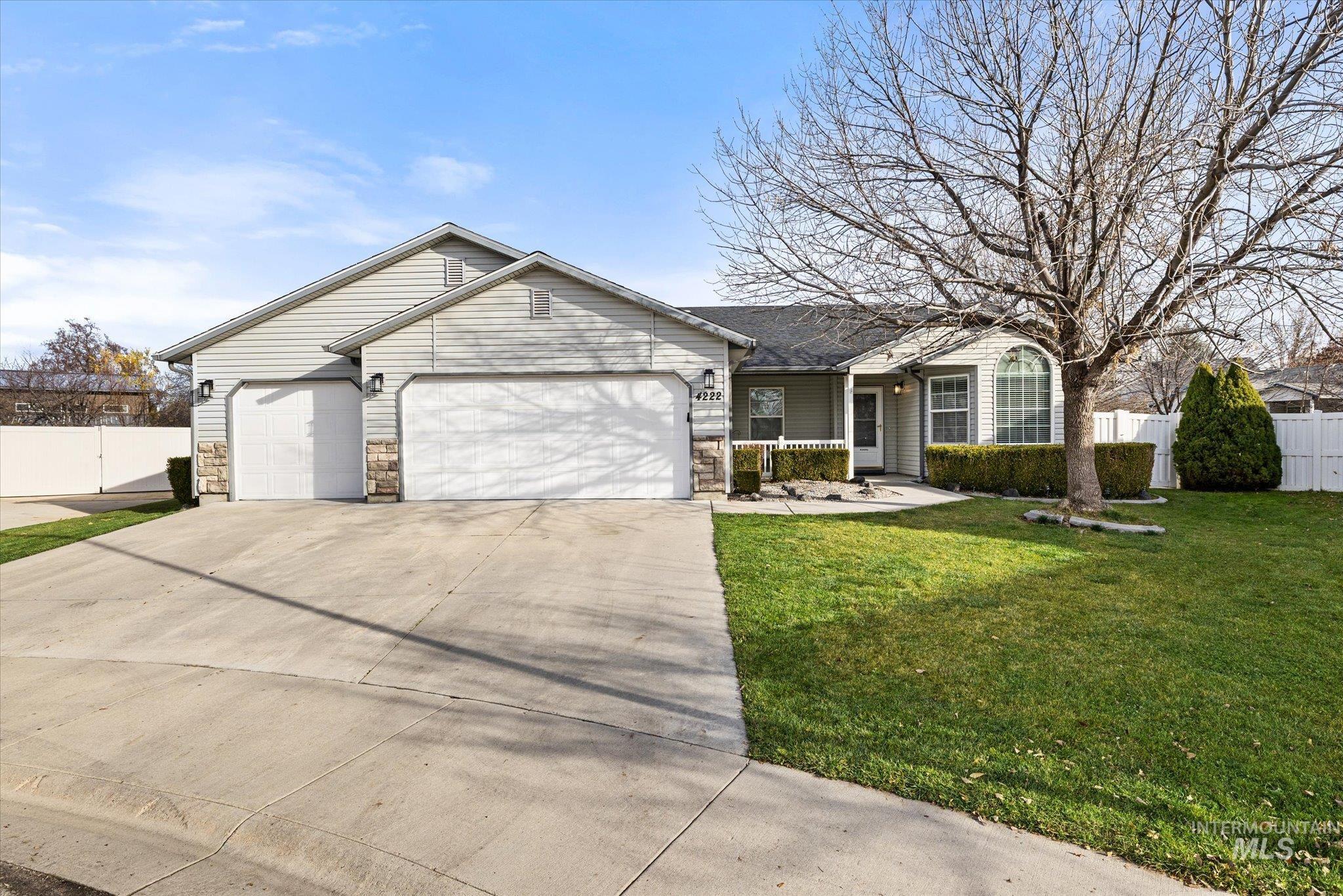 Single story home featuring an attached garage, concrete driveway, and covered porch