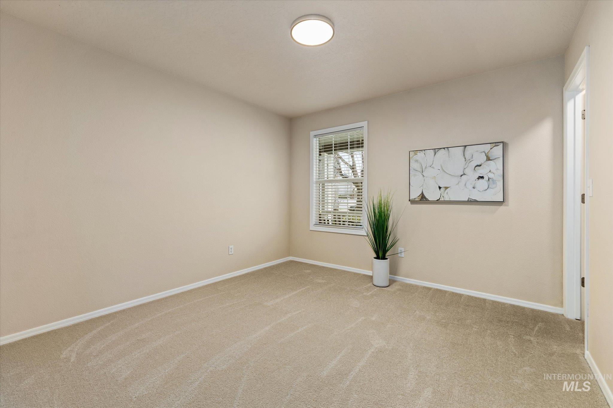 Unfurnished room with light colored carpet and baseboards